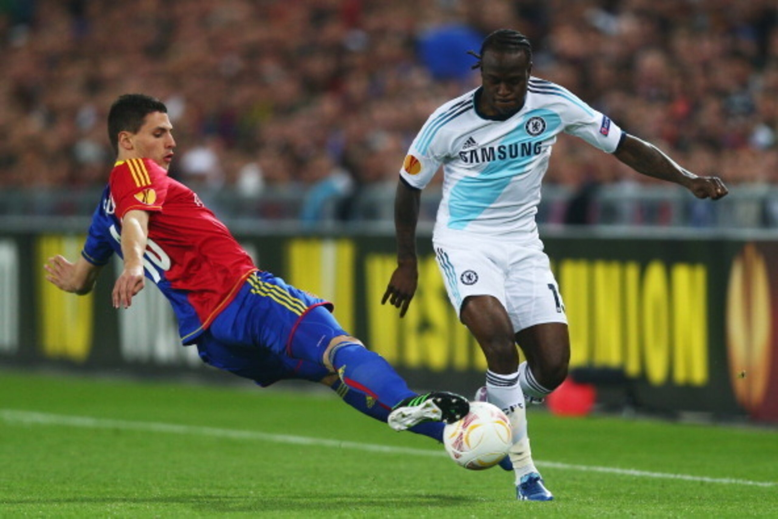 BASEL, SWITZERLAND - APRIL 25:  Victor Moses (R) of Chelsea is challenged by Fabian Schar (L) of FC Basel during the UEFA Europa League Semi Final First Leg match between FC Basel 1893 and Chelsea at St. Jakob Stadium on April 25, 2013 in Basel, Switzerla
