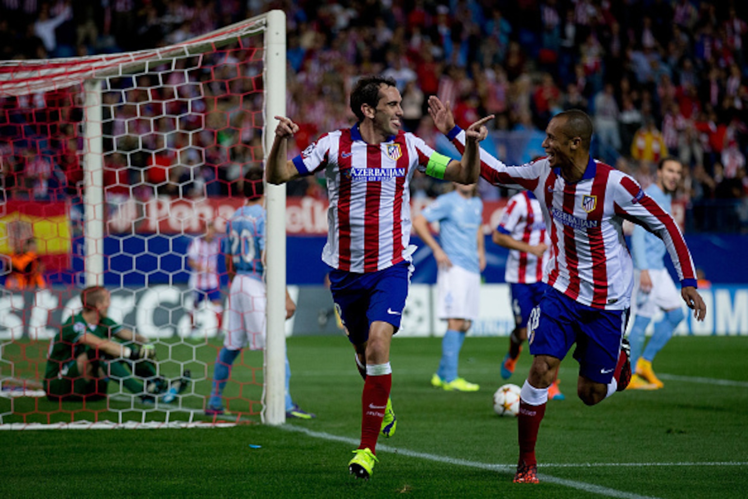 MADRID, SPAIN - OCTOBER 22:  Diego Godin (L) celebrates scoring their fourth goal with teammate Joao Miranda (R) during the UEFA Champions League group A match between Club Atletico de Madrid and Malmo FF at Vicente Calderon stadium on October 22, 2014 in