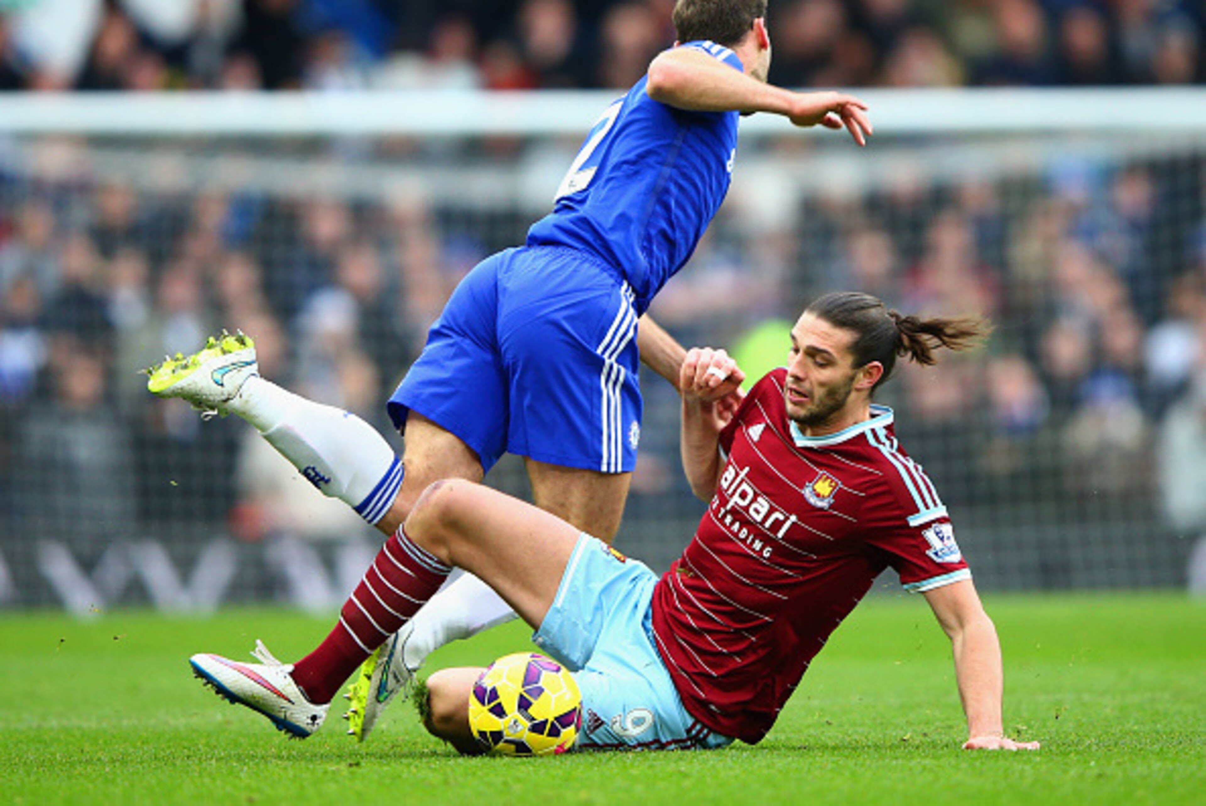 LONDON, ENGLAND - DECEMBER 26:  Andy Carroll of West Ham tackles Branislav Ivanovic of Chelsea during the Barclays Premier League match between Chelsea and West Ham United at Stamford Bridge on December 26, 2014 in London, England.  (Photo by Ian Walton/G