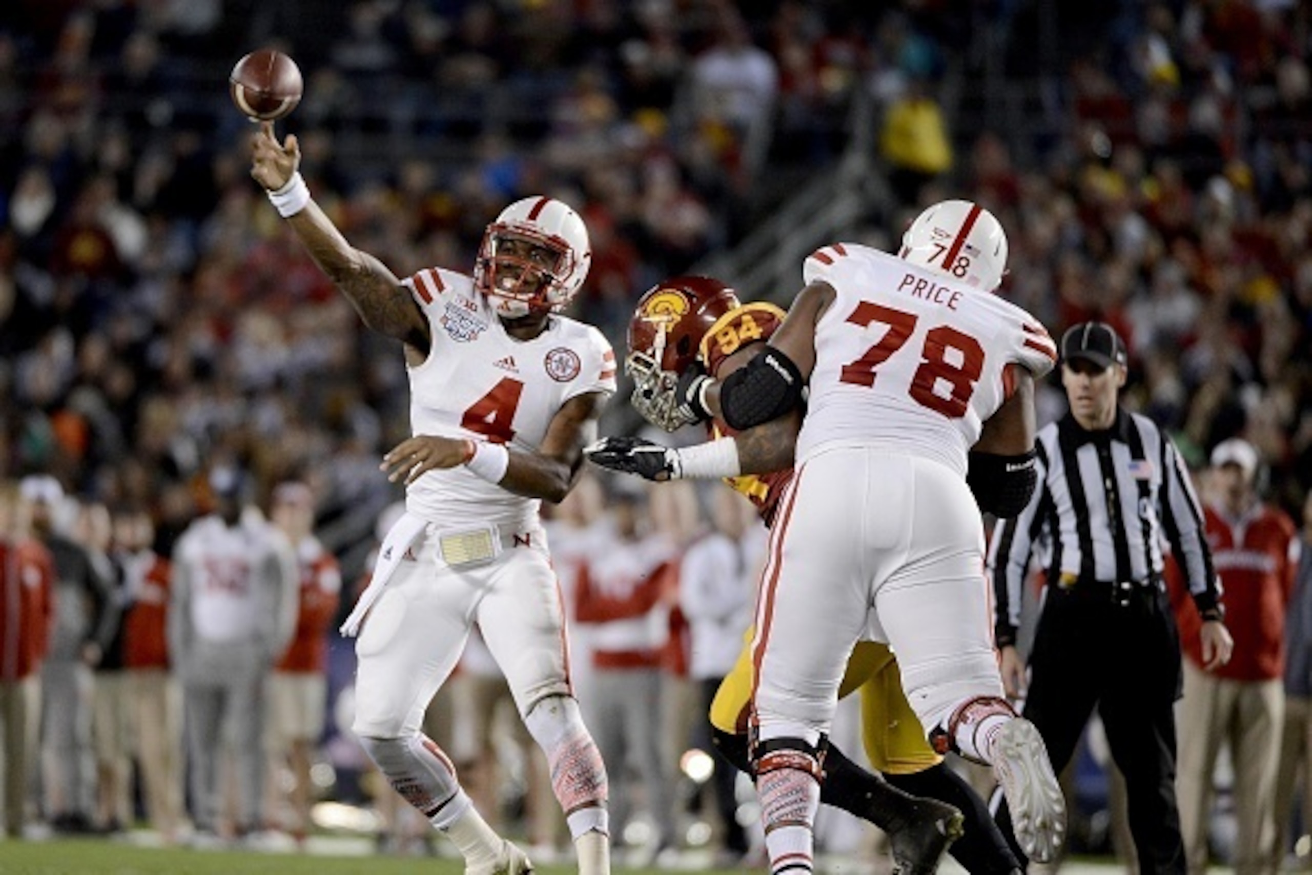 SAN DIEGO, CA-  DECEMBER 27:  Quarterback Tommy Armstrong Jr. #4 of the Nebraska Cornhuskers throws under pressure against the USC Trojans during the National University Holiday Bowl on December 27, 2014 at Qualcomm Stadium in San Diego, California. (Phot