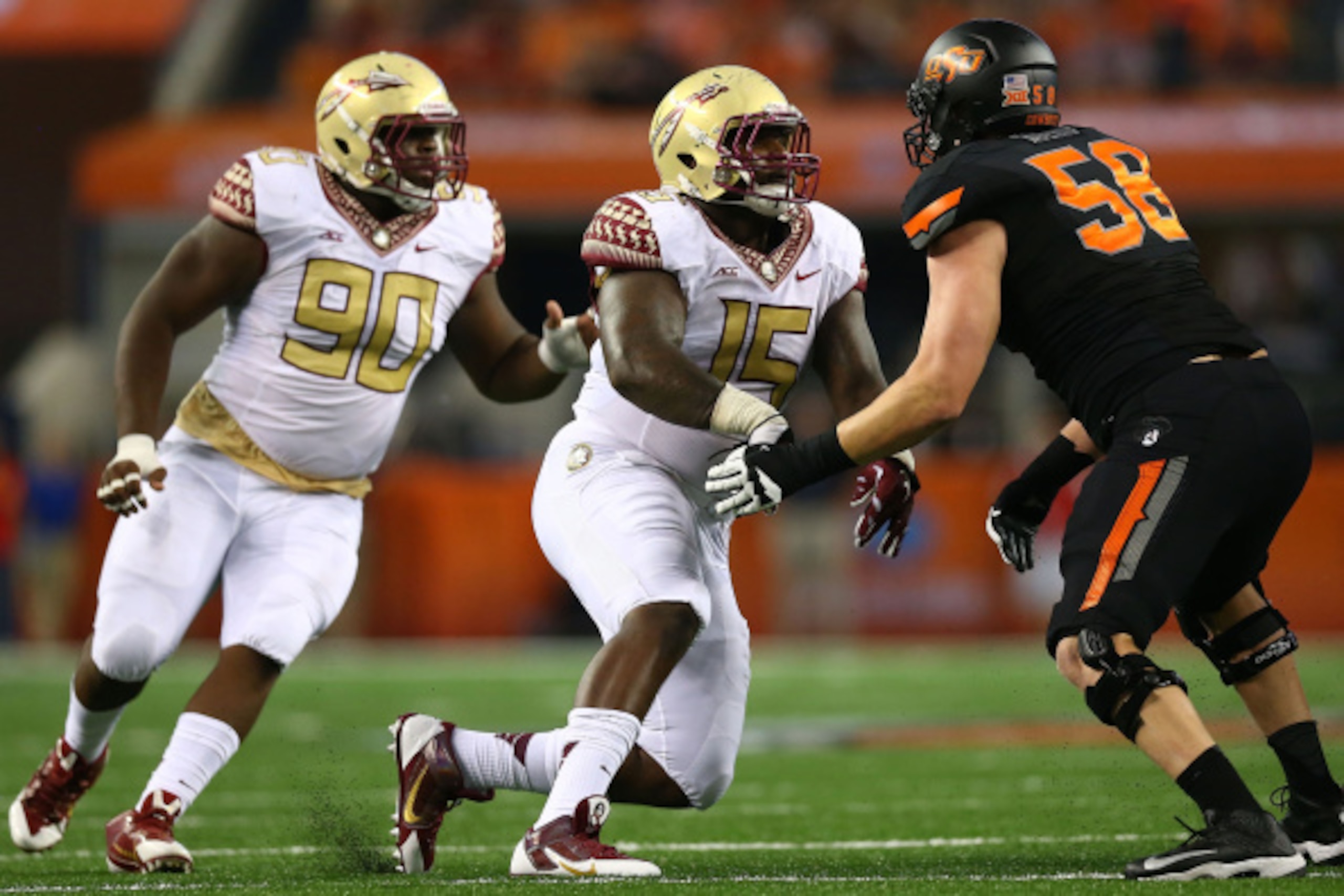 ARLINGTON, TX - AUGUST 30:  Mario Edwards Jr. #15 and Eddie Goldman #90 of the Florida State Seminoles rush as Daniel Koenig #58 of the Oklahoma State Cowboys blocks in the first half of the Advocare Cowboys Classic at AT&T Stadium on August 30, 2014 in A