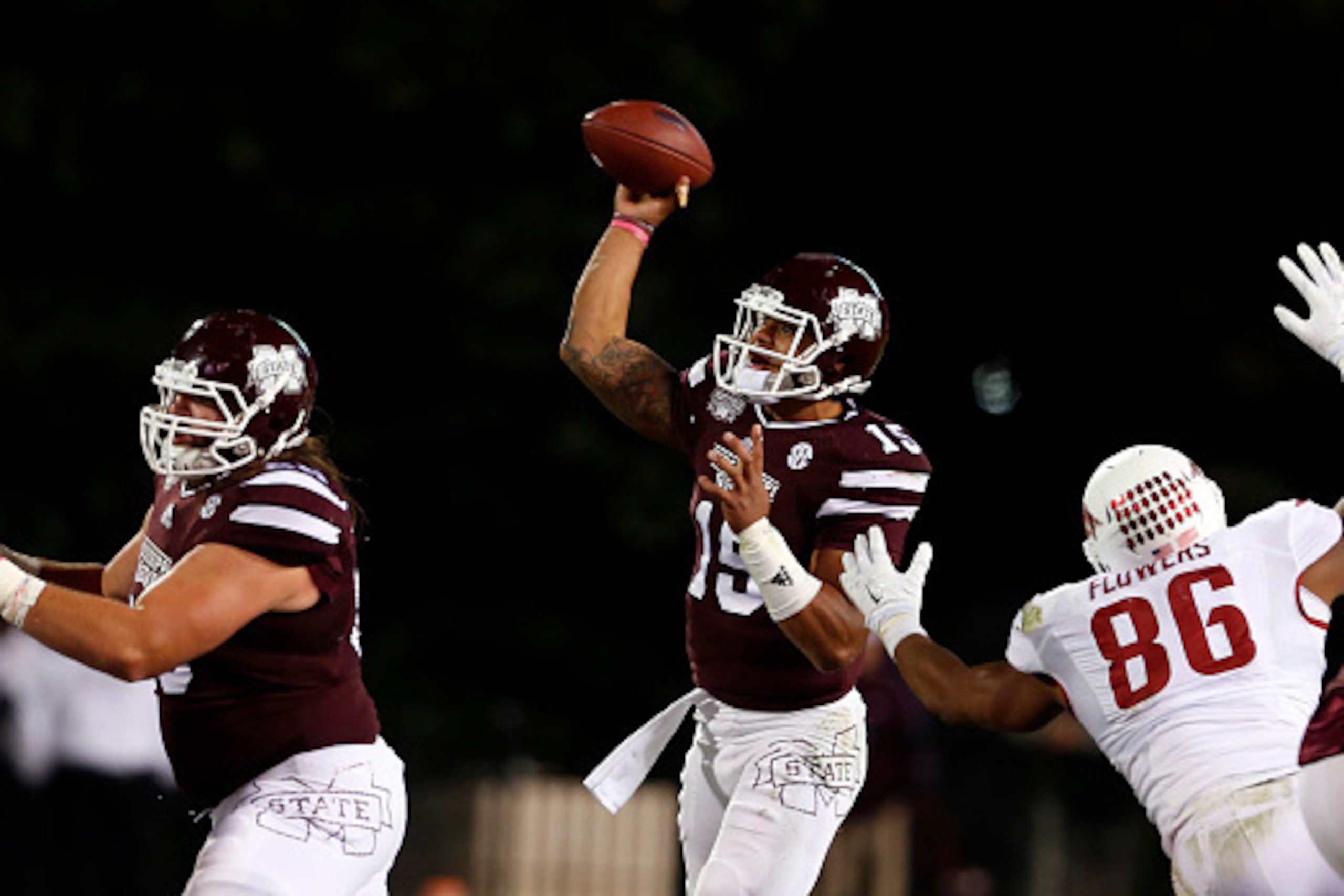 STARKVILLE, MS-NOVEMBER 1:  Dak Prescott #15 of the Mississippi State Bulldogs throws a pass while under pressure from Trey Flowers #86 of the Arkansas Razorbacks in the second half at Davis Wade Stadium on November 1, 2014, in Starkville, Mississippi. (P