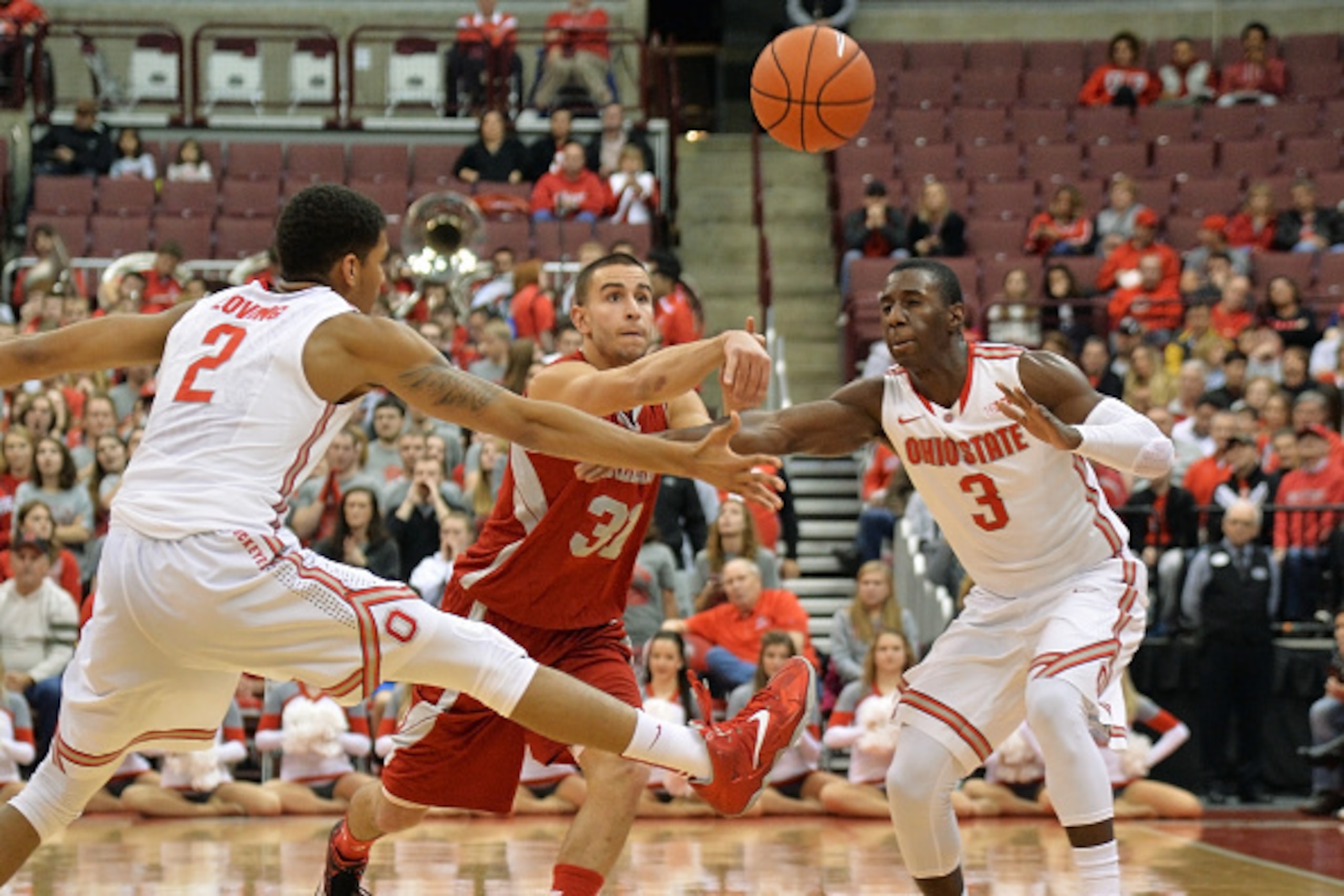 COLUMBUS, OH - NOVEMBER 23:  Steve Glowiak #31 of the Sacred Heart Pioneers passes through the defensive pressure of Marc Loving #2 of the Ohio State Buckeyes and Shannon Scott #3 of the Ohio State Buckeyes in the first half on November 23, 2014 at Value 
