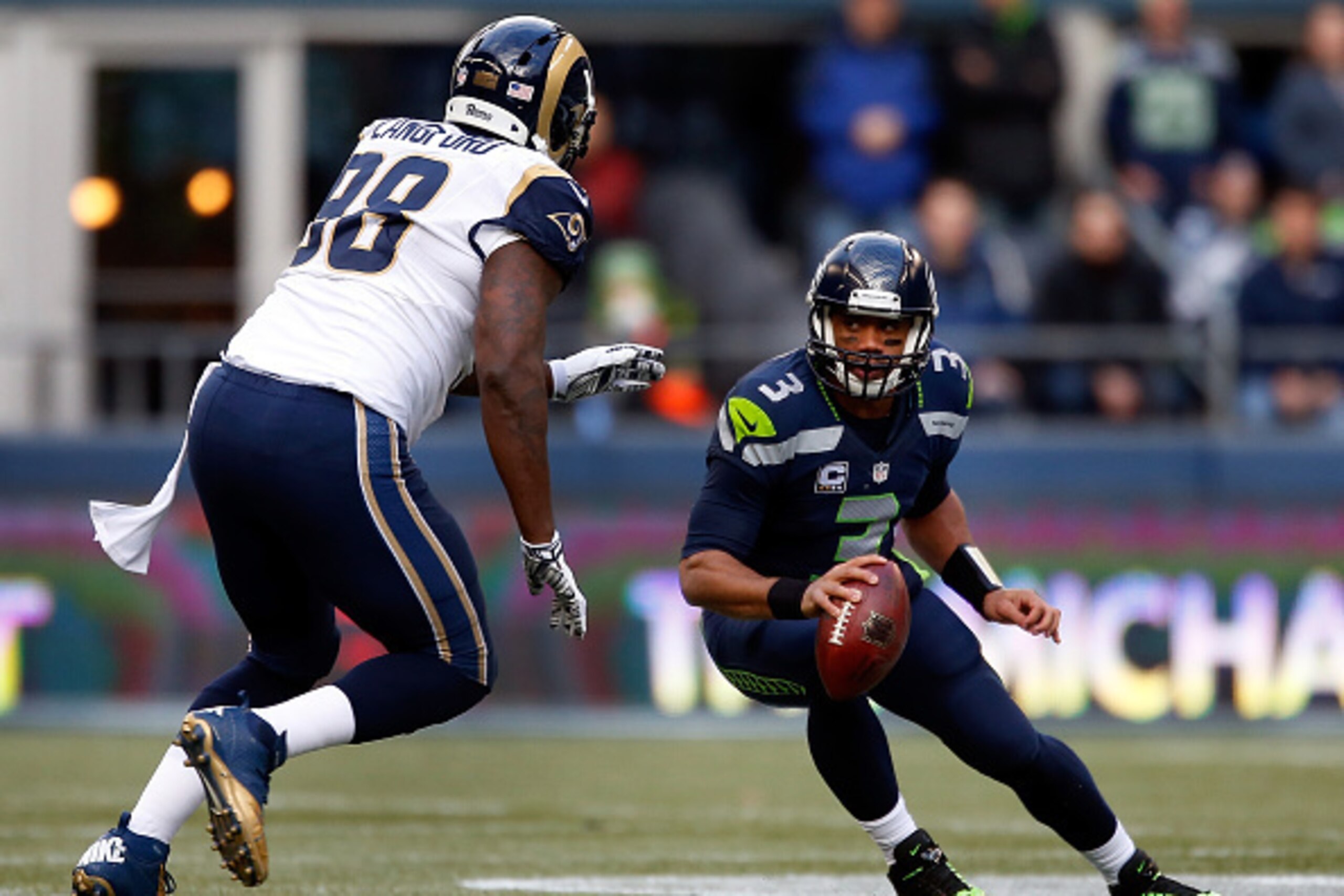 SEATTLE, WA - DECEMBER 28:  Quarterback Russell Wilson #3 of the Seattle Seahawks tries to avoid the rush of defensive tackle Kendall Langford #98 of the St. Louis Rams during the first quarter of the game at CenturyLink Field on December 28, 2014 in Seat