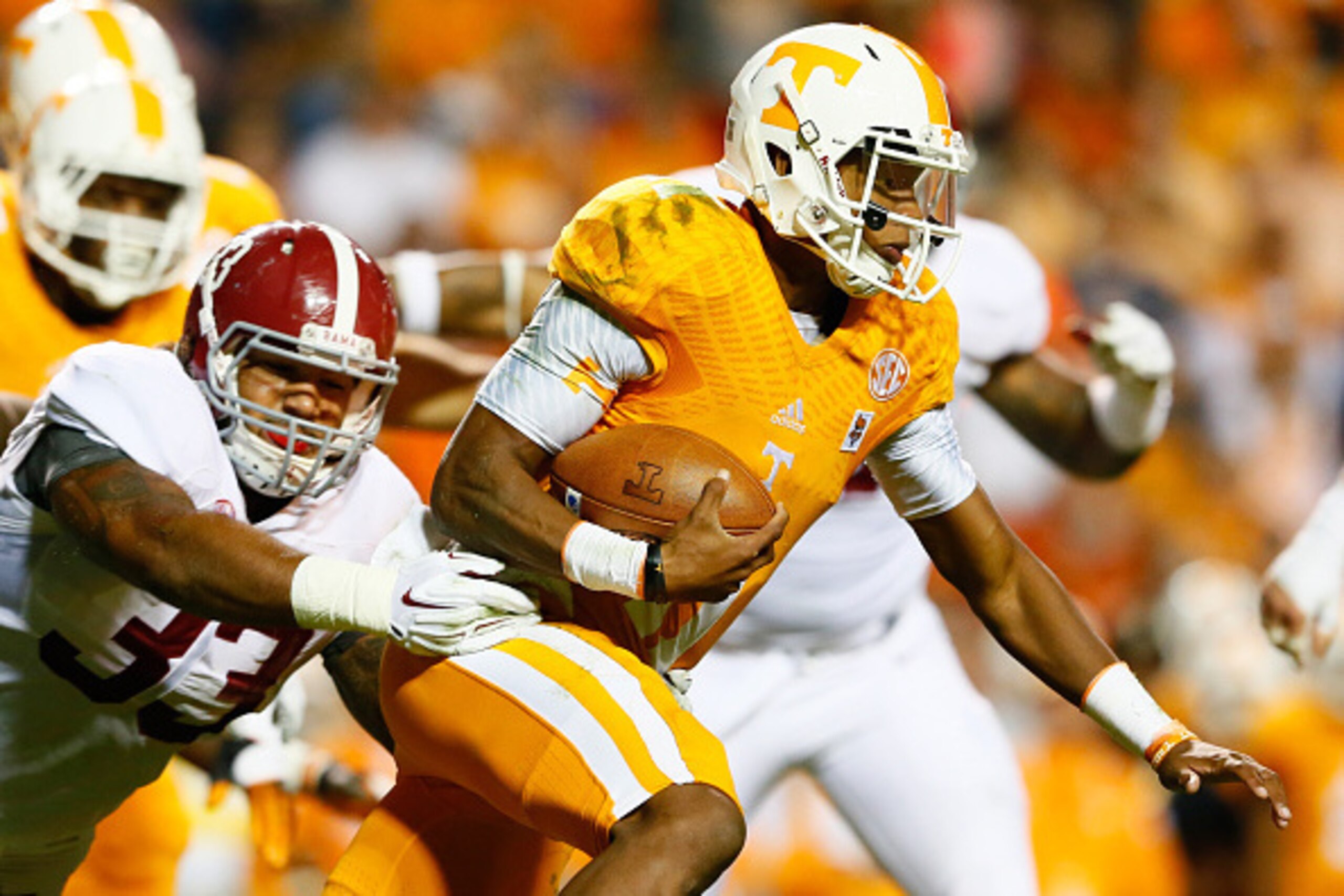 KNOXVILLE, TN - OCTOBER 25:  Joshua Dobbs #11 of the Tennessee Volunteers breaks a tackle by Trey DePriest #33 of the Alabama Crimson Tide at Neyland Stadium on October 25, 2014 in Knoxville, Tennessee.  (Photo by Kevin C. Cox/Getty Images)