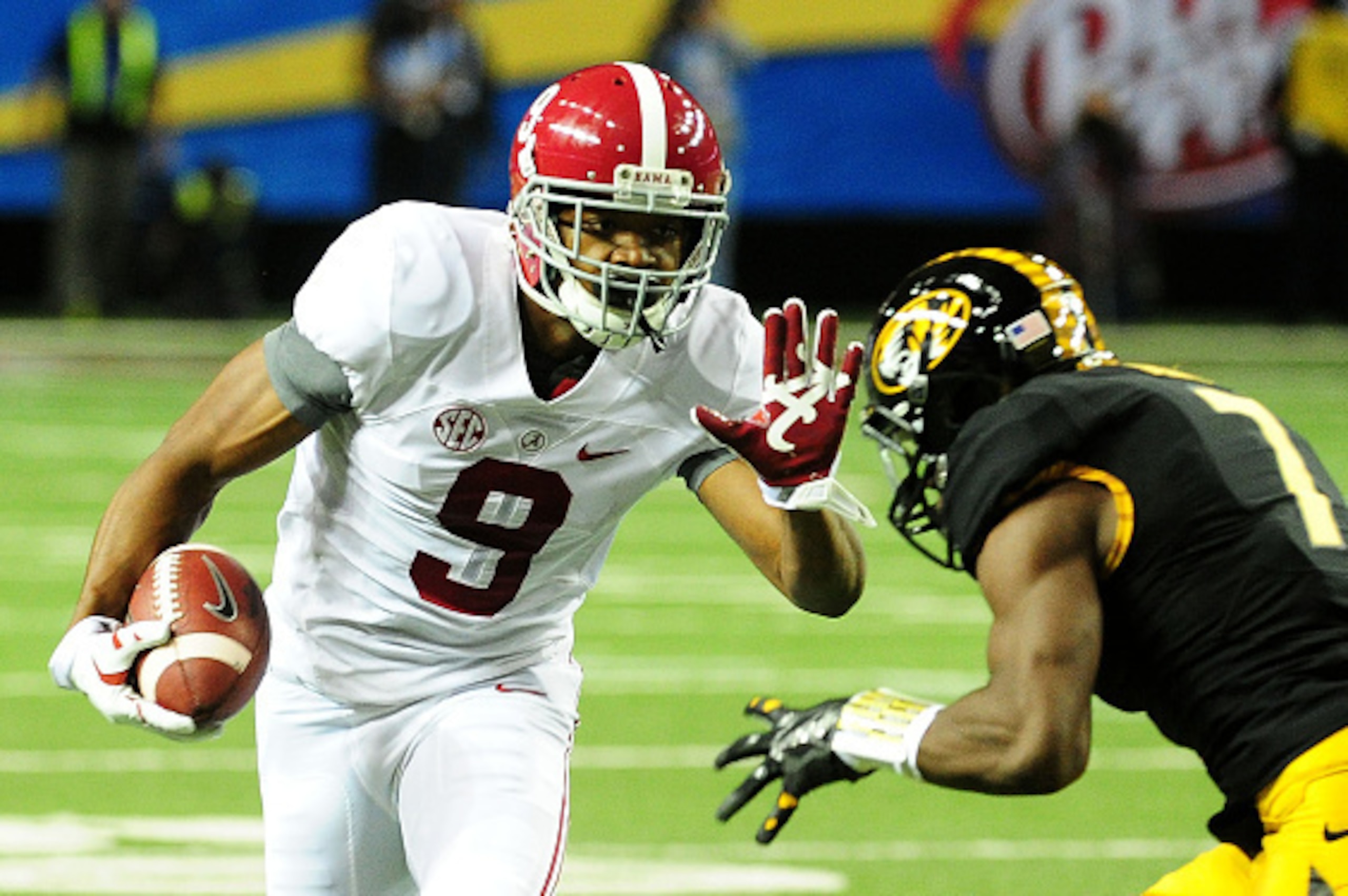 ATLANTA, GA - DECEMBER 06:  Amari Cooper #9 of the Alabama Crimson Tide tries to avoid the tackle of Kenya Dennis #7 of the Missouri Tigers in the first quarter of the SEC Championship game at the Georgia Dome on December 6, 2014 in Atlanta, Georgia.  (Ph
