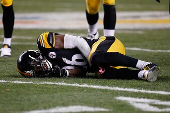 PITTSBURGH, PA - DECEMBER 28:  Le'Veon Bell #26 of the Pittsburgh Steelers is injured after being hit by Reggie Nelson #20 of the Cincinnati Bengals during the third quarter at Heinz Field on December 28, 2014 in Pittsburgh, Pennsylvania.  (Photo by Grego