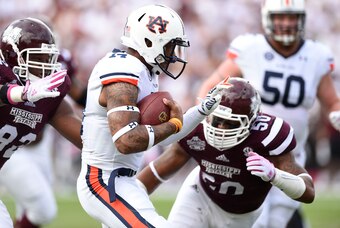 Oct 11, 2014; Starkville, MS, USA; Auburn Tigers quarterback Nick Marshall (14) scrambles up the field under pressure form Mississippi State Bulldogs defensive lineman Kaleb Eulls (92) and linebacker Benardrick McKinney (50)  during the first quarter at D