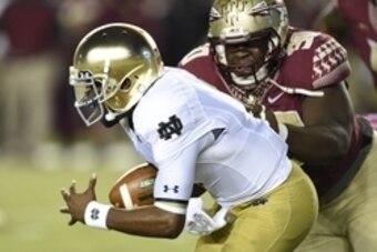 Oct 18, 2014; Tallahassee, FL, USA;  Notre Dame Fighting Irish quarterback Everett Golson (5) tries to avoid the sack from Florida State Seminoles defensive tackle Eddie Goldman (90) during the first quarter at Doak Campbell Stadium. Mandatory Credit: Joh