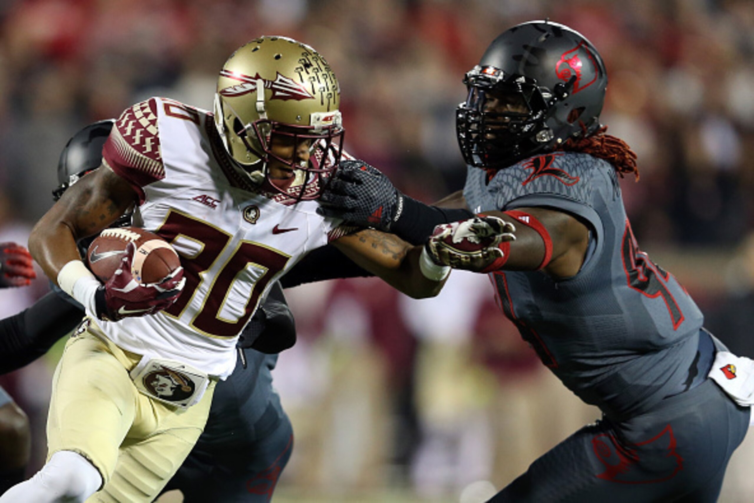 LOUISVILLE, KY - OCTOBER 30:  Rashad Greene #80 of the Florida State Seminoles runs with the ball after a catch in the first quarter against Lorenzo Mauldin #94 of the Louisville Cardinals during their game at Papa John's Cardinal Stadium on October 30, 2
