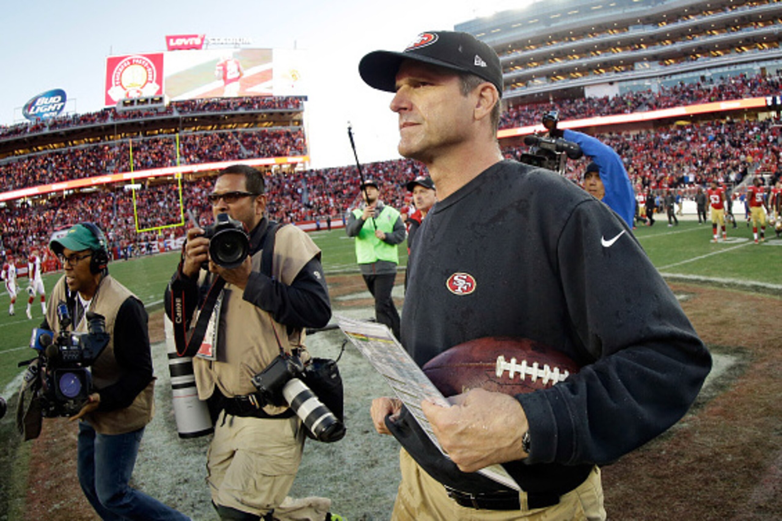 SANTA CLARA, CA - DECEMBER 28:  Head coach Jim Harbaugh of the San Francisco 49ers runs onto the field to shake hands with head coach Bruce Arians of the Arizona Cardinals after their game at Levi's Stadium on December 28, 2014 in Santa Clara, California.
