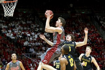 Dec 3, 2014; Salt Lake City, UT, USA; Utah Utes forward Jakob Poeltl (42) runs past Wichita State Shockers guard Evan Wessel (3) and to the basket during the first half at Jon M. Huntsman Center. Mandatory Credit: Chris Nicoll-USA TODAY Sports
