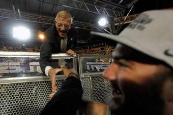 MIAMI GARDENS, FL - JANUARY 04:  ESPN analyst Lou Holtz congratulates players from the West Virginia Mountaineers after they won 70-33 against the Clemson Tigers during the Discover Orange Bowl at Sun Life Stadium on January 4, 2012 in Miami Gardens, Flor