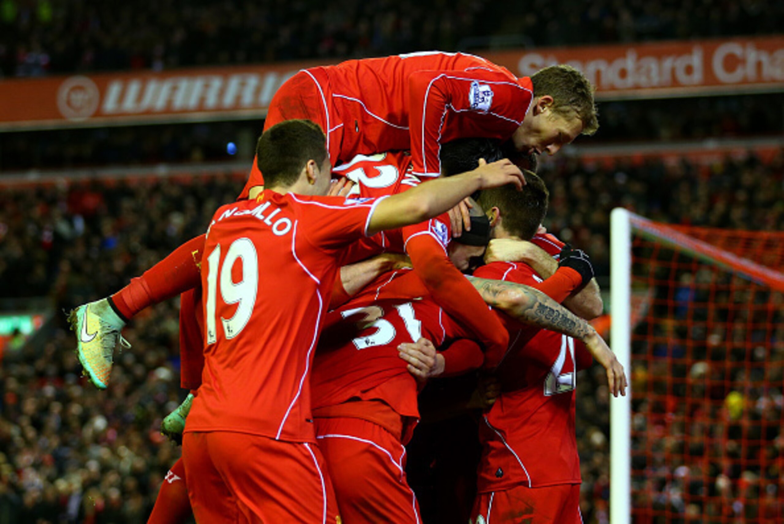 LIVERPOOL, ENGLAND - DECEMBER 29:  Adam Lallana of Liverpool celebrates with team-mates after scoring his team's second goal during the Barclays Premier League match between Liverpool and Swansea City at Anfield on December 29, 2014 in Liverpool, England.