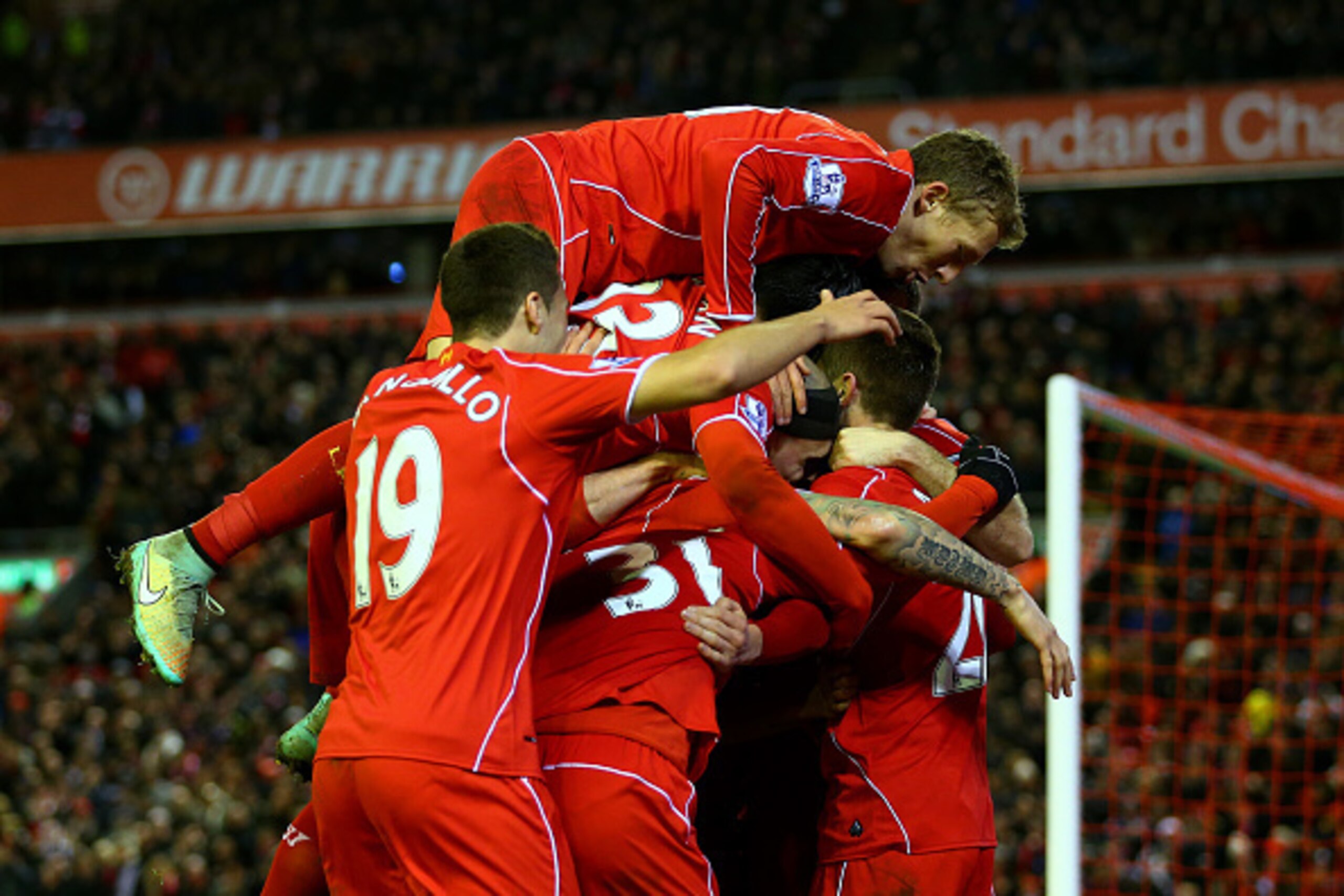 LIVERPOOL, ENGLAND - DECEMBER 29:  Adam Lallana of Liverpool celebrates with team-mates after scoring his team's second goal during the Barclays Premier League match between Liverpool and Swansea City at Anfield on December 29, 2014 in Liverpool, England.