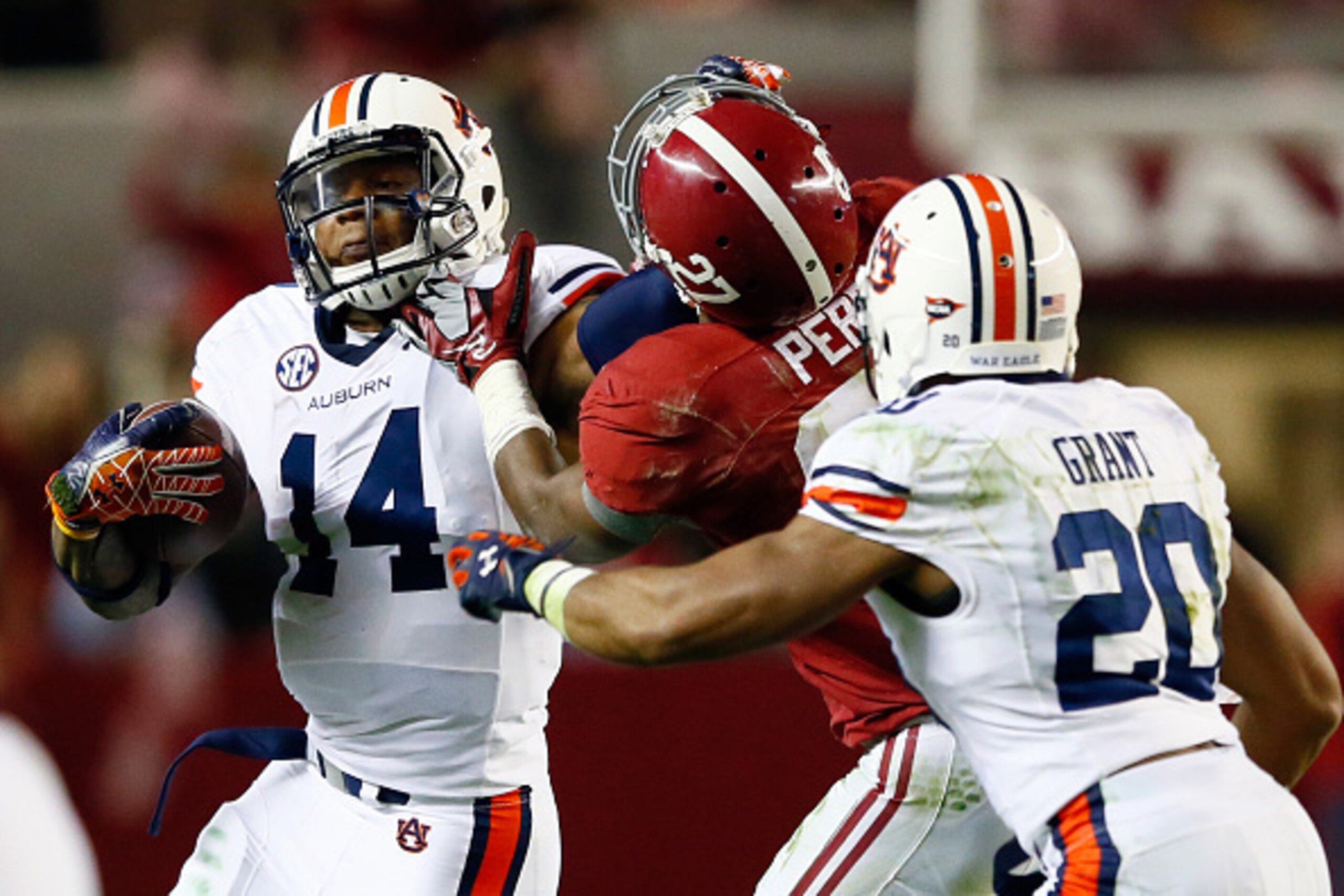 TUSCALOOSA, AL - NOVEMBER 29:  Nick Marshall #14 of the Auburn Tigers stiff arms Nick Perry #27 of the Alabama Crimson Tide in the second quarter during the Iron Bowl at Bryant-Denny Stadium on November 29, 2014 in Tuscaloosa, Alabama.  (Photo by Kevin C.