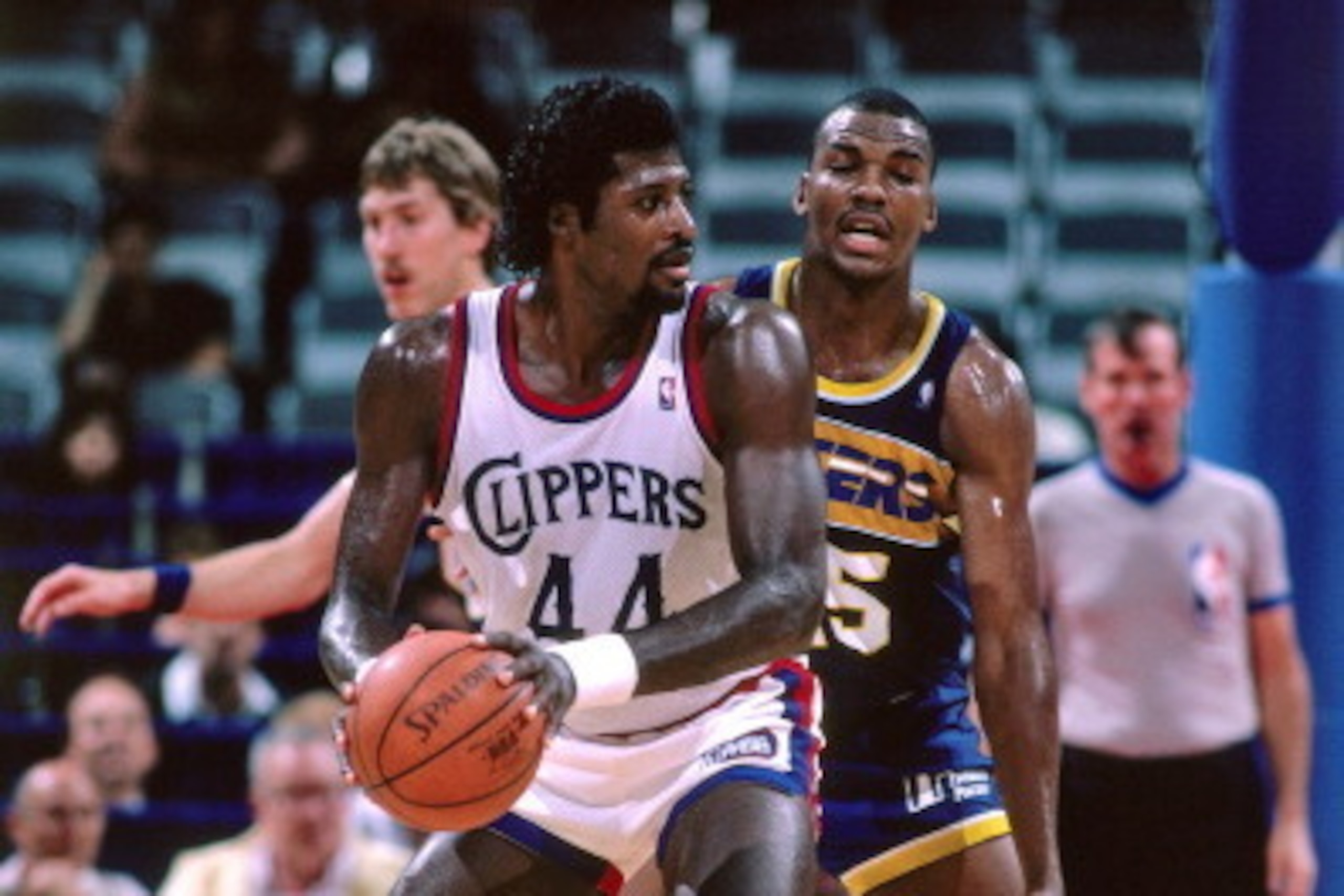 LOS ANGELES - CIRCA 1987: Michael Cage #44 of the Los Angeles Clippers dribbles against Chuck Person #45 of the Indiana Pacers during a game played circa 1987 at the LA Sports Arena in Los Angeles, California. NOTE TO USER: User expressly acknowledges and