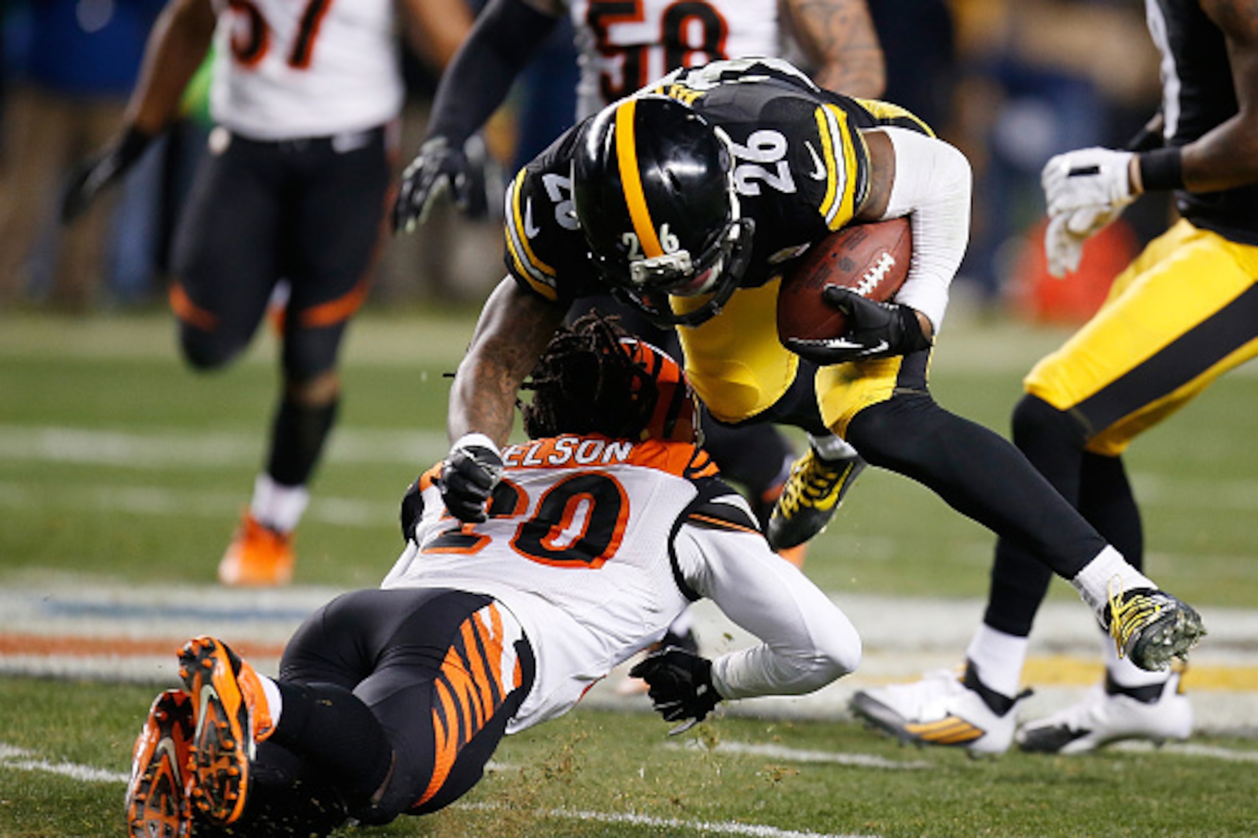 PITTSBURGH, PA - DECEMBER 28:  Le'Veon Bell #26 of the Pittsburgh Steelers is injured after being hit by Reggie Nelson #20 of the Cincinnati Bengals during the third quarter at Heinz Field on December 28, 2014 in Pittsburgh, Pennsylvania.  (Photo by Grego