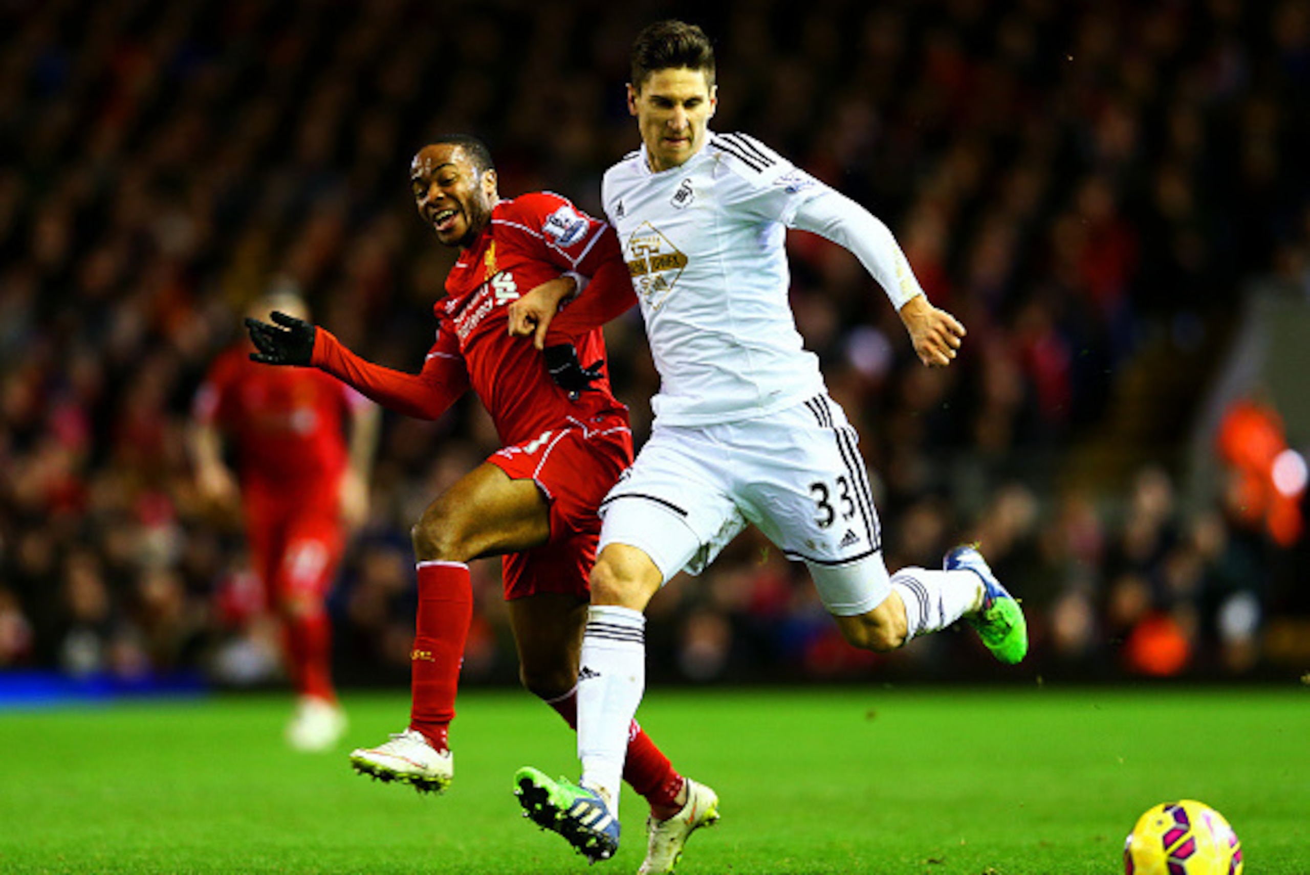 LIVERPOOL, ENGLAND - DECEMBER 29:  Federico Fernandez of Swansea City holds off Raheem Sterling of Liverpool during the Barclays Premier League match between Liverpool and Swansea City at Anfield on December 29, 2014 in Liverpool, England.  (Photo by Cliv