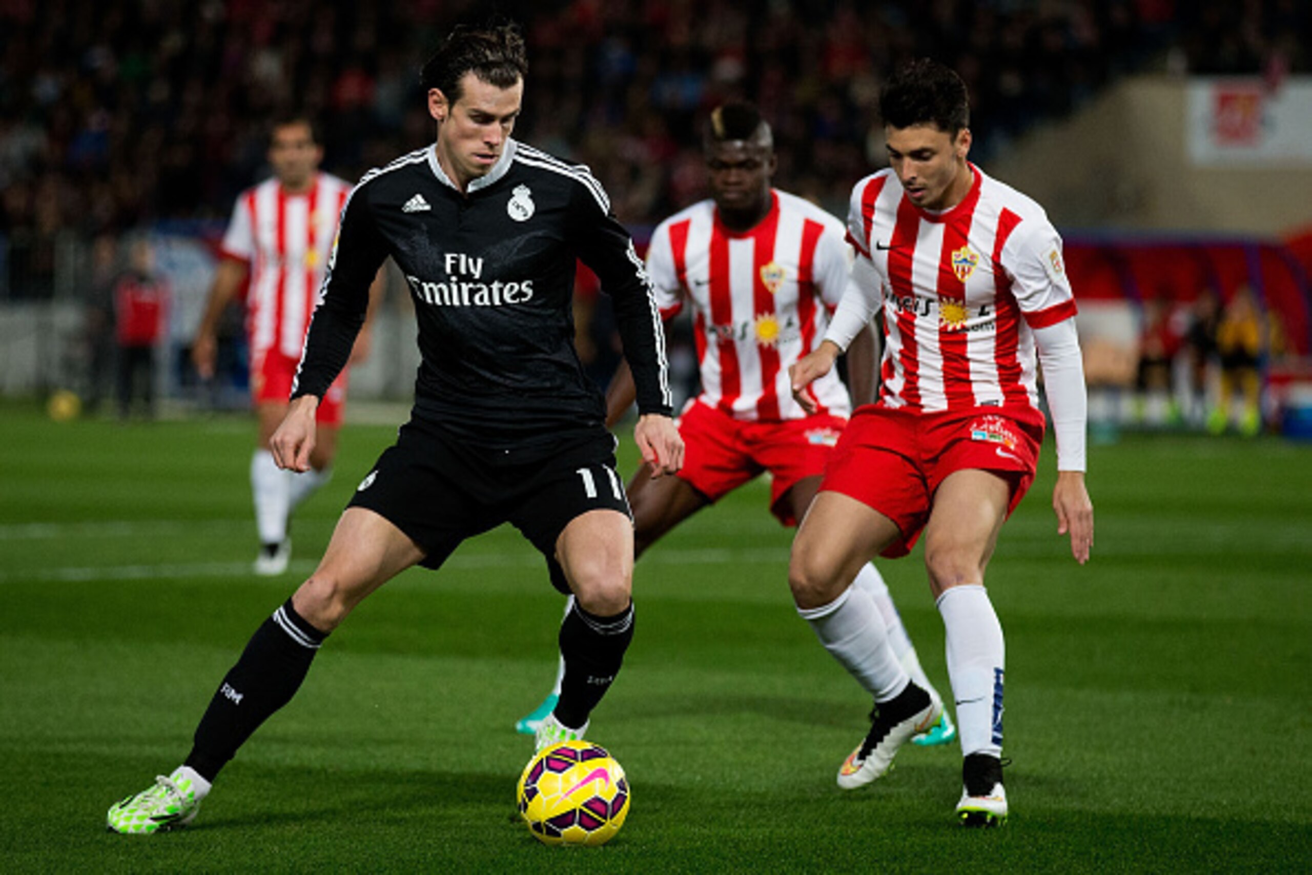 ALMERIA, SPAIN - DECEMBER 12:  Gareth Bale (L) of Real Madrid CF competes for the ball with Joaquin Navarro JImenez (R) of Almeria UD during the La Liga match between UD Almeria and Real Madrid CF at Juegos del Mediterraneo stadium on December 12, 2014 in