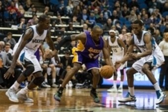 Dec 14, 2014; Minneapolis, MN, USA; Los Angeles Lakers guard Kobe Bryant (24) protects the ball from Minnesota Timberwolves center Gorgui Dieng (5) and guard Andrew Wiggins (22) during the fourth quarter at Target Center. The Lakers defeated the Timberwol