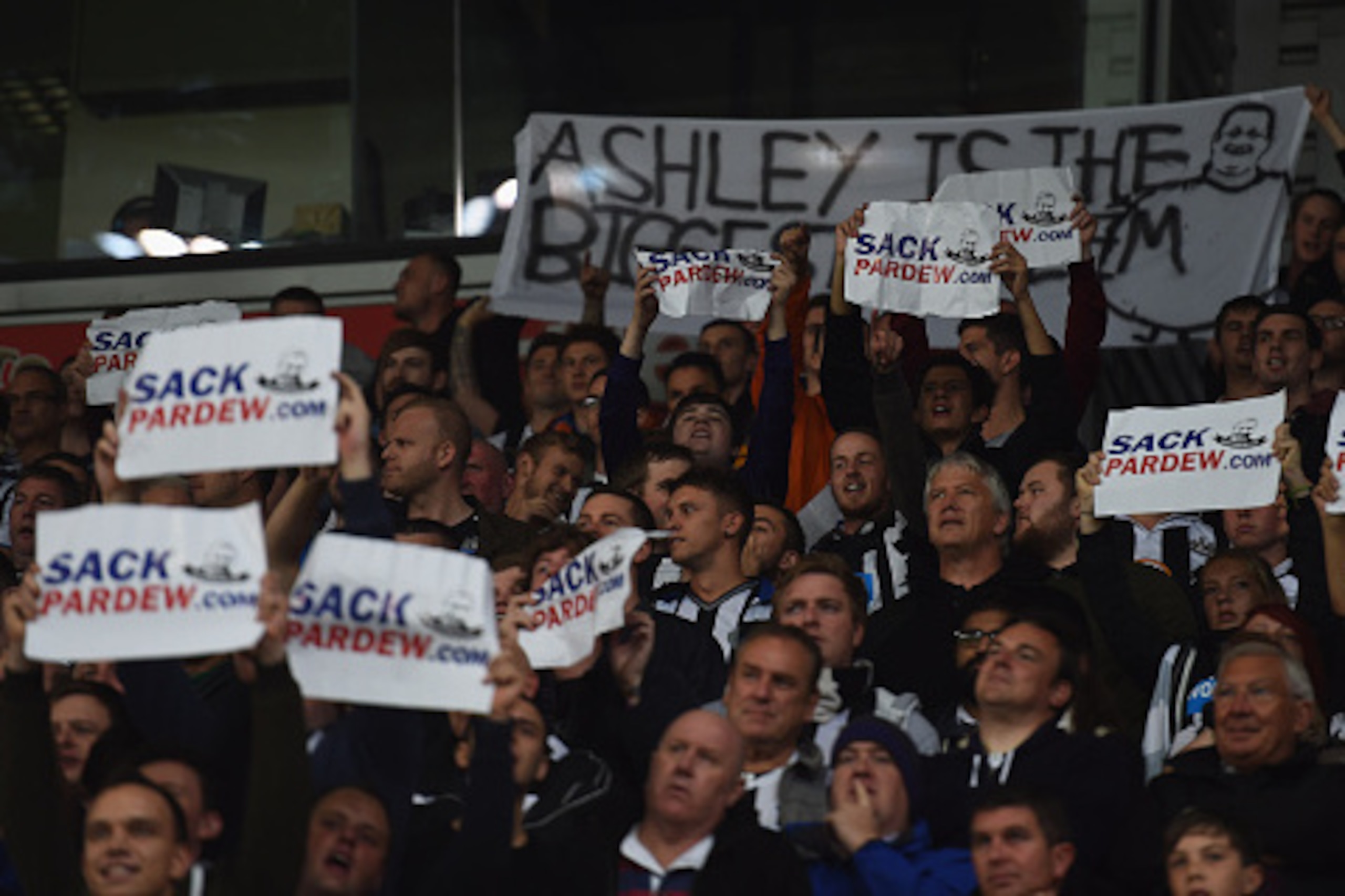 STOKE ON TRENT, ENGLAND - SEPTEMBER 29:  Newcastle fans hold up signs calling for Alan Pardew, manager of Newcastle United, to be sacked as they watch the Barclays Premier League match between Stoke City and Newcastle United at Britannia Stadium on Septem
