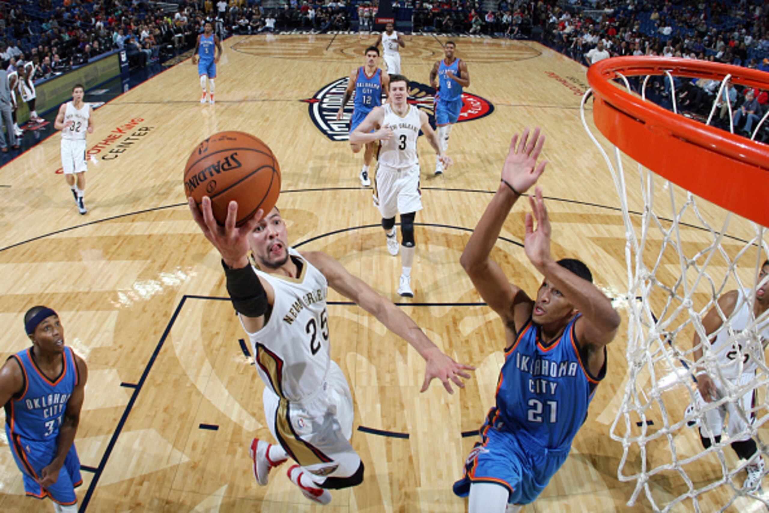 NEW ORLEANS, LA - OCTOBER 16: Austin Rivers #25 of the New Orleans Pelicans goes for a lay up as Andre Roberson #21 of the Oklahoma City Thunder defends the basket during an NBA game on October 16, 2014 at the Smoothie King Center in New Orleans, Louisian