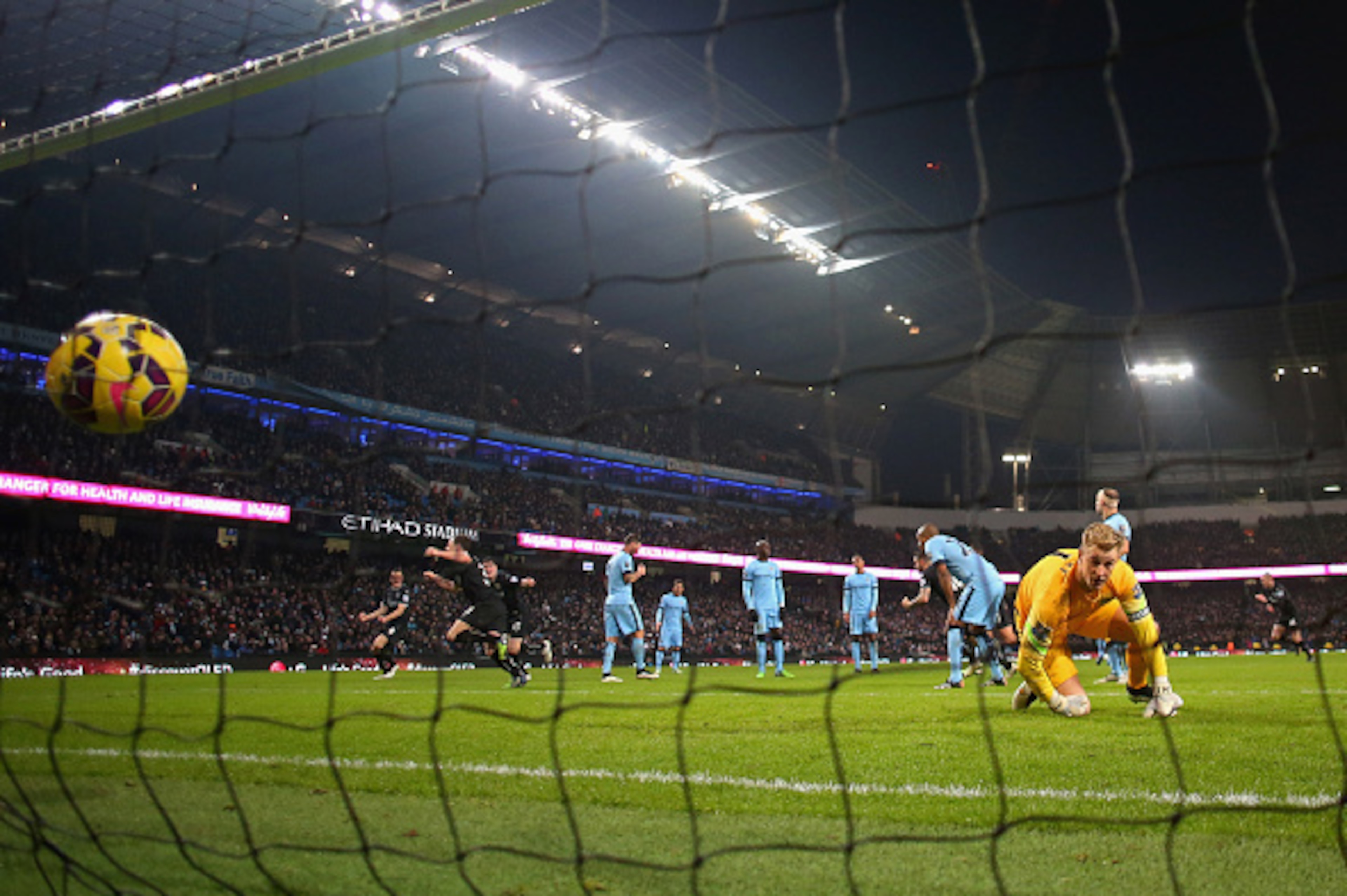 MANCHESTER, ENGLAND - DECEMBER 28:  Joe Hart of Manchester City looks at the ball in the net as Ashley Barnes of Burnley celebrates scoring the equalizing goal during the Barclays Premier League match between Manchester City and Burnley at Etihad Stadium 