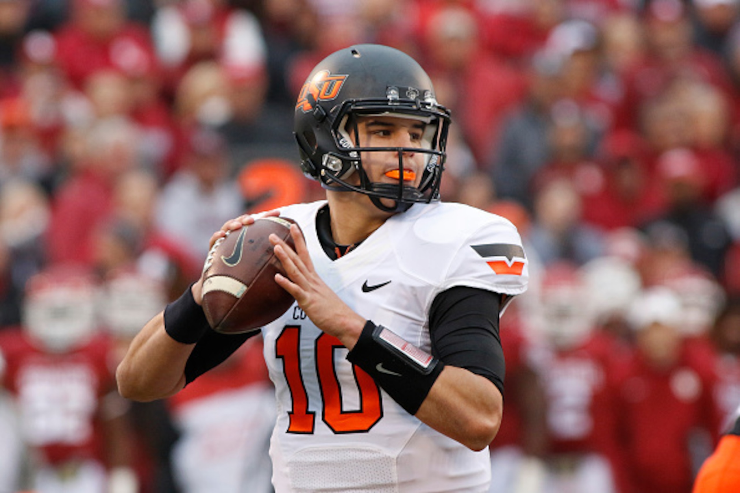 NORMAN, OK - DECEMBER 6:  Quarterback Mason Rudolph #10 of the Oklahoma State Cowboys looks to throw against the Oklahoma Sooners December 6, 2014 at Gaylord Family-Oklahoma Memorial Stadium in Norman, Oklahoma. The Cowboys defeated the Sooners 38-35 in o