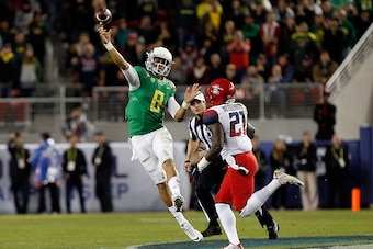 SANTA CLARA, CA - DECEMBER 05: Marcus Mariota #8 of the Oregon Ducks releases over coverage by Tra'Mayne Bondurant #21 of the Arizona Wildcats during the first half of the PAC-12 Championships at Levi's Stadium on December 5, 2014 in Santa Clara, Californ