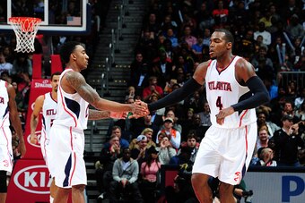 ATLANTA, GA - DECEMBER 30: Jeff Teague #0 and Paul Millsap #4 of the Atlanta Hawks celebrate after a score against the Cleveland Cavaliers on December 30, 2014 at Philips Arena in Atlanta, Georgia.  NOTE TO USER: User expressly acknowledges and agrees tha