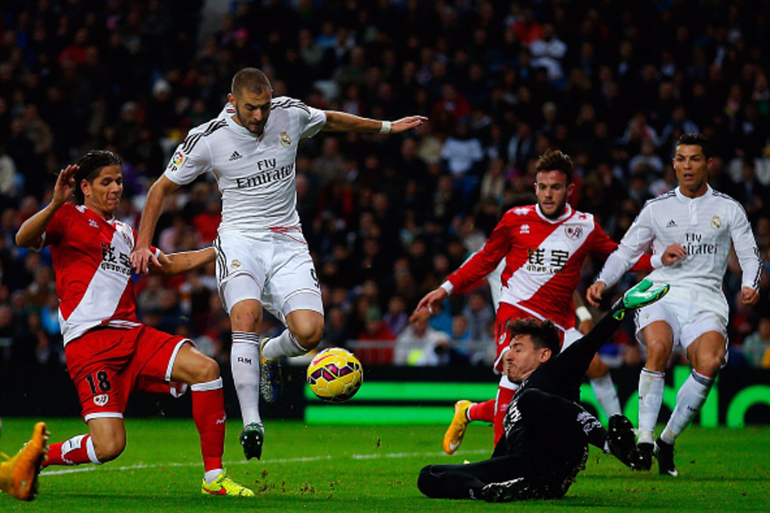 MADRID, SPAIN - NOVEMBER 08: Karim Benzema (2ndL) of Real Madrid CF competes for the ball with Ze Castro (L) of Rayo Vallecano de Madrid and his teammate goalkeeper Cristian Dario Alvarez Azad (R) during the La Liga match between Real Madrid CF and Rayo V