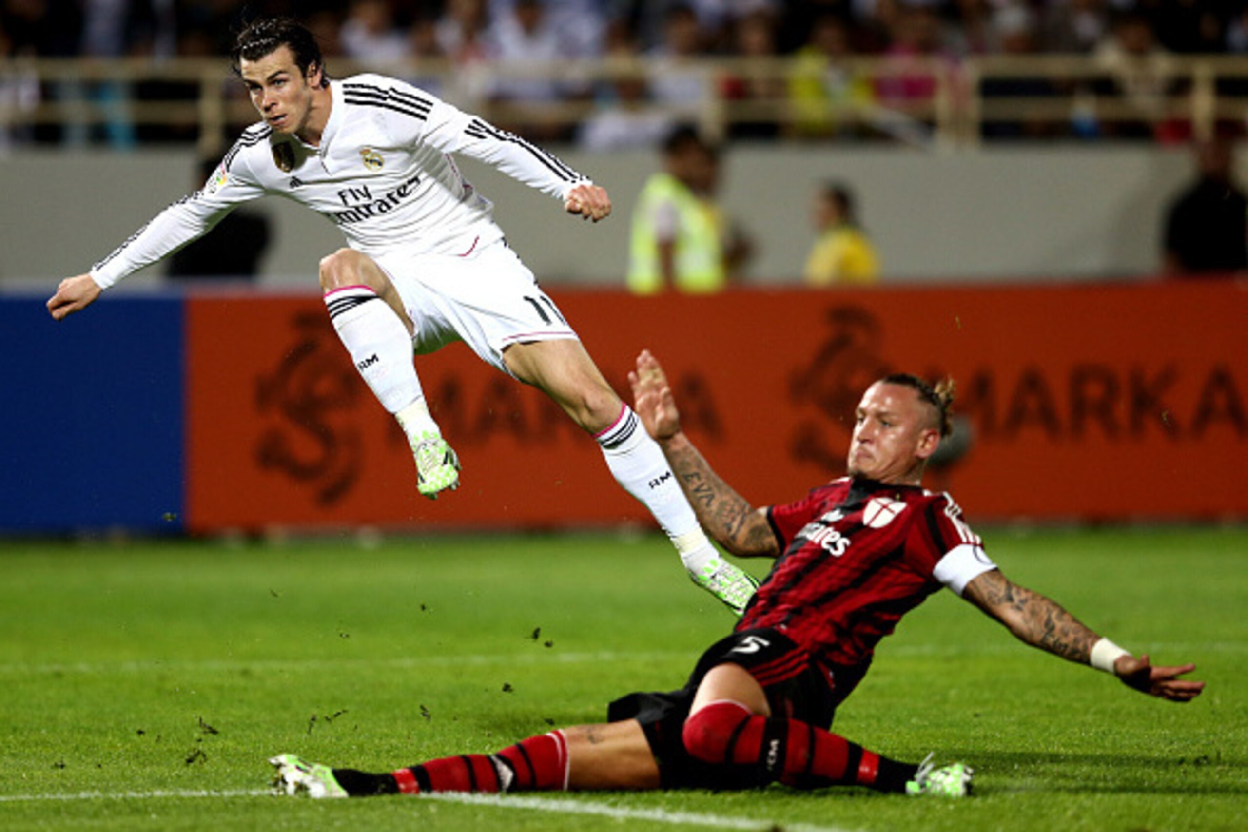DUBAI, UNITED ARAB EMIRATES - DECEMBER 30: Gareth Bale of Real Madrid strikes at goal as he is tackled by Philippe Mexes of AC Milan during the Dubai Football Challenge match between AC Milan and Real Madrid at The Sevens Stadium on December 30, 2014 in DUBAI, UNITED ARAB EMIRATES - DECEMBER 30: Gareth Bale of Real Madrid strikes at goal as he is tackled by Philippe Mexes of AC Milan during the Dubai Football Challenge match between AC Milan and Real Madrid at The Sevens Stadium on December 30, 2014 in