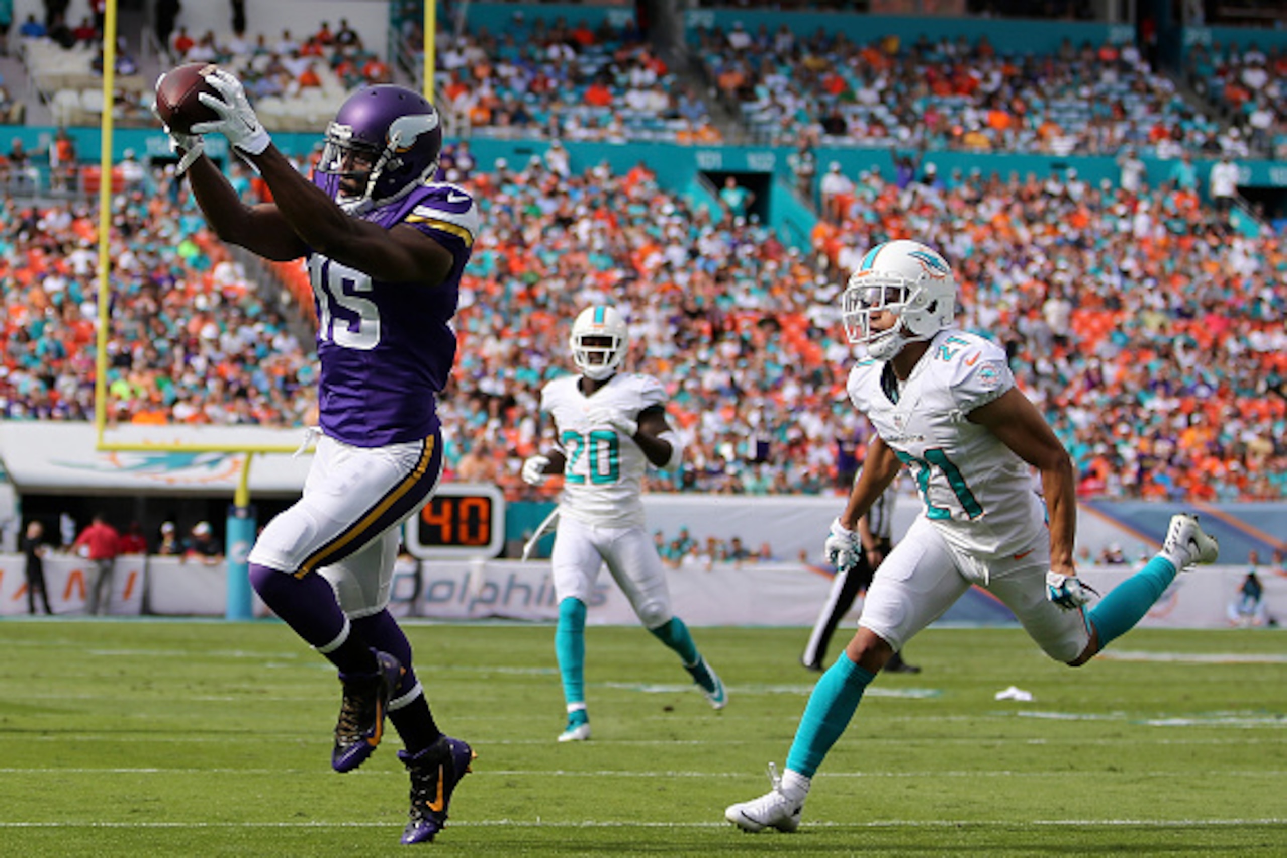 MIAMI GARDENS, FL - DECEMBER 21:  Wide receiver Greg Jennings #15 of the Minnesota Vikings catches the ball to score a second quarter touchdown as cornerback Brent Grimes #21 of the Miami Dolphins trails during a game at Sun Life Stadium on December 21, 2