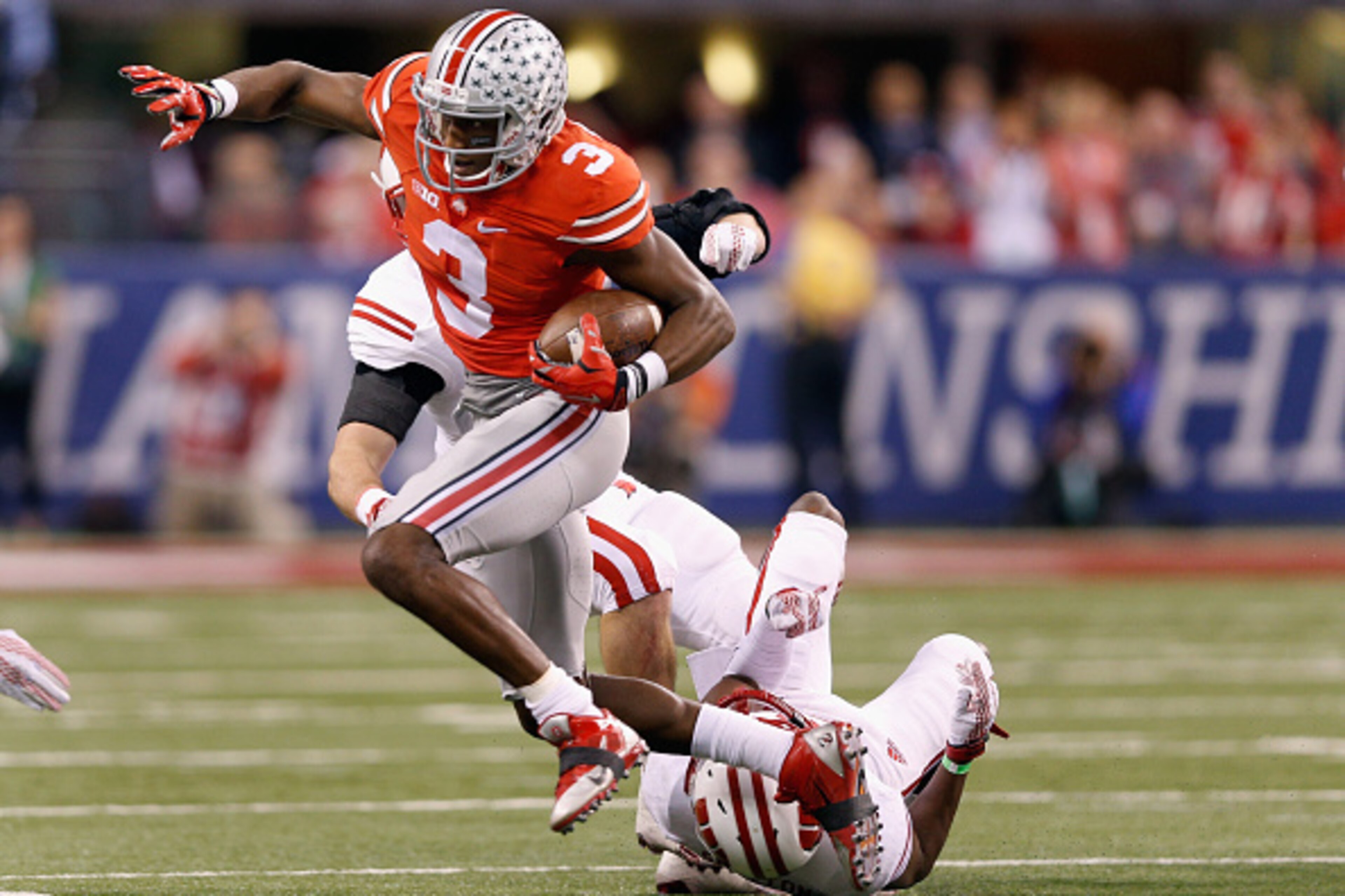 INDIANAPOLIS, IN - DECEMBER 06: Michael Thomas #3 of the Ohio State Buckeyes gets tripped up over Wisconsin Badgers defense in the second quarter of the Big Ten Championship at Lucas Oil Stadium on December 6, 2014 in Indianapolis, Indiana. (Photo by Jo INDIANAPOLIS, IN - DECEMBER 06: Michael Thomas #3 of the Ohio State Buckeyes gets tripped up over Wisconsin Badgers defense in the second quarter of the Big Ten Championship at Lucas Oil Stadium on December 6, 2014 in Indianapolis, Indiana. (Photo by Jo