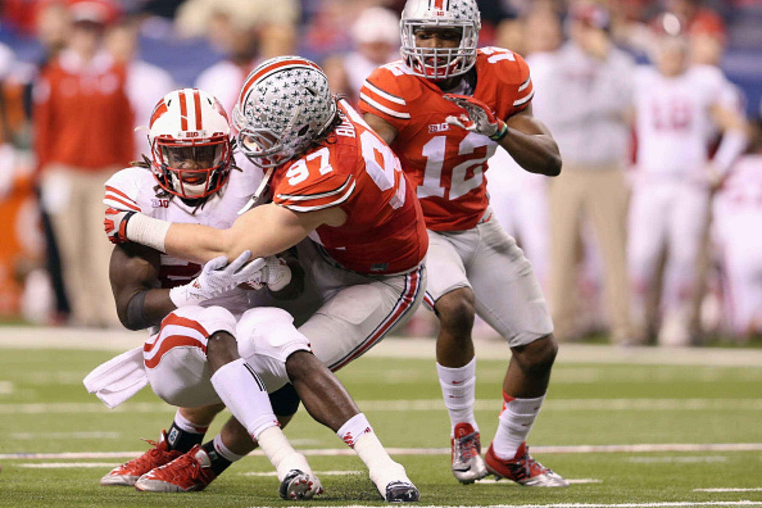 INDIANAPOLIS, IN - DECEMBER 06:  Joey Bosa #97 of the Ohio State Buckeyes tackles Melvin Gordon #25 of the Wisconsin Badgers in the first half of the Big Ten Championship at Lucas Oil Stadium on December 6, 2014 in Indianapolis, Indiana.  (Photo by Andy L