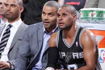 PORTLAND, OR - FEBRUARY 19:  Tony Parker #9 and Patty Mills #8 of the San Antonio Spurs talk on the bench during the game against the Portland Trail Blazers on February 19, 2014 at the Moda Center Arena in Portland, Oregon. NOTE TO USER: User expressly ac