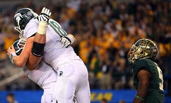 ARLINGTON, TX - JANUARY 01:  Connor Cook #18 of the Michigan State Spartans and Brian Allen #65 of the Michigan State Spartans celebrate after a touchdown pass to Keith Mumphery #25 of the Michigan State Spartans wins the game as Ryan Reid #9 of the Baylo
