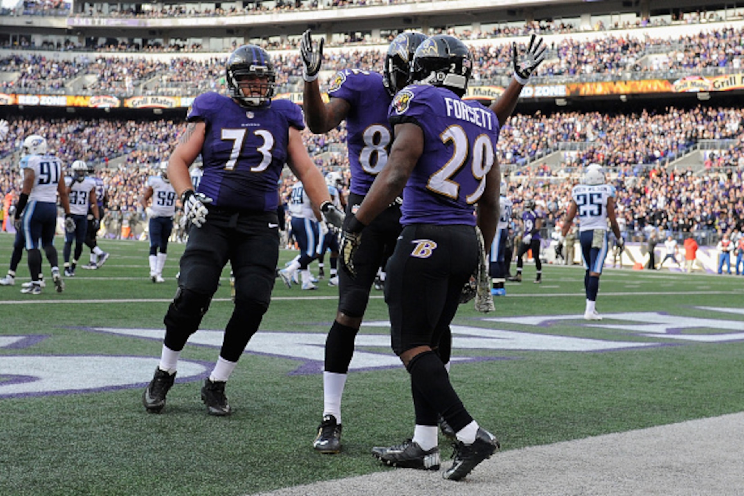BALTIMORE, MD - NOVEMBER 09: Running back Justin Forsett #29 of the Baltimore Ravens is congratulated by teammates  Torrey Smith and  Marshal Yanda after scoring a third quarter touchdown against the Tennessee Titans at M&T Bank Stadium on November 9, 201