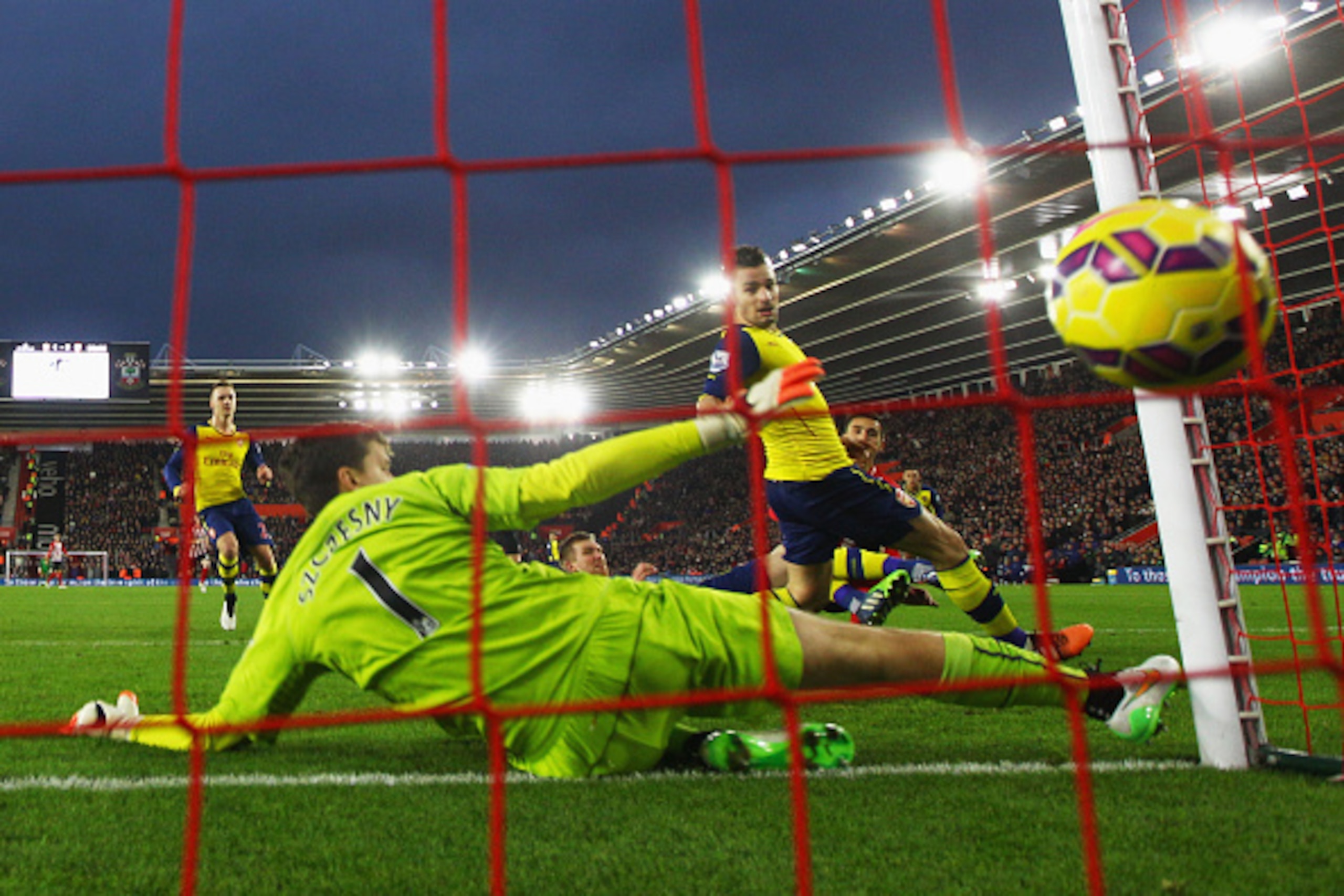 SOUTHAMPTON, ENGLAND - JANUARY 01:  Dusan Tadic of Southampton (R) scores their second goal past Wojciech Szczesny (1) and Mathieu Debuchy of Arsenal (2R) during the Barclays Premier League match between Southampton and Arsenal at St Mary's Stadium on Jan