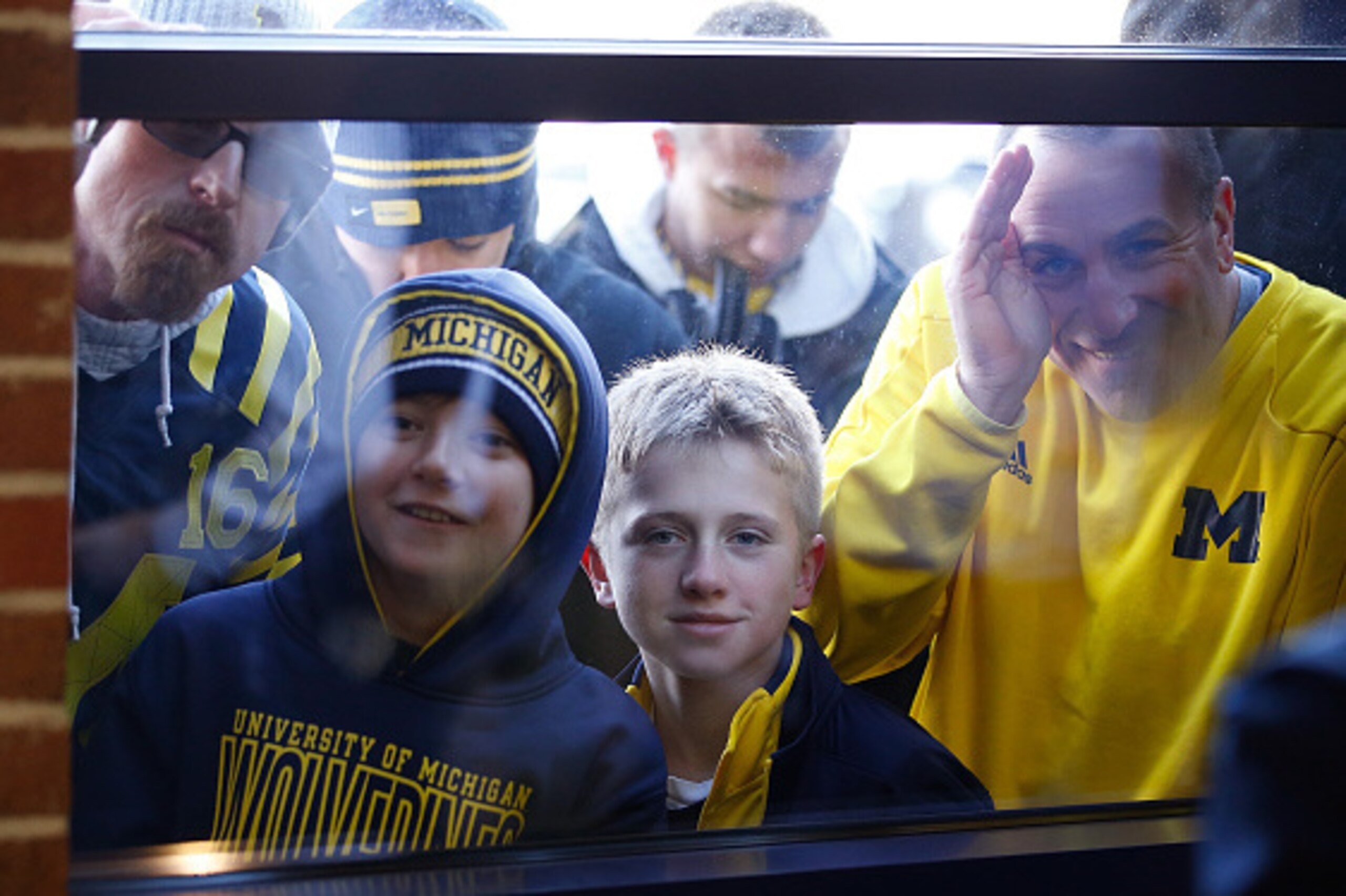 ANN ARBOR, MI - DECEMBER 30: Fans peak through the window as Jim Harbaugh is introduced as the new Head Coach of the University of Michigan football team at the Junge Family Champions Center on December 30, 2014 in Ann Arbor, Michigan. (Photo by Gregory ANN ARBOR, MI - DECEMBER 30: Fans peak through the window as Jim Harbaugh is introduced as the new Head Coach of the University of Michigan football team at the Junge Family Champions Center on December 30, 2014 in Ann Arbor, Michigan. (Photo by Gregory