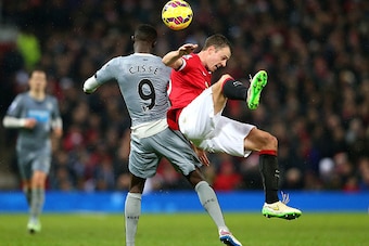 MANCHESTER, ENGLAND - DECEMBER 26:  Jonny Evans of Manchester United tangles with Papiss Cisse of Newcastle United during the Barclays Premier League match between Manchester United and Newcastle United at Old Trafford on December 26, 2014 in Manchester, 