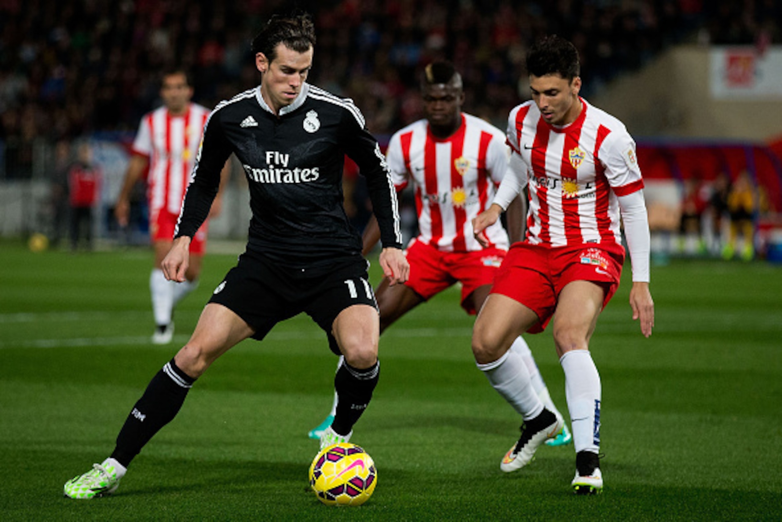 ALMERIA, SPAIN - DECEMBER 12:  Gareth Bale (L) of Real Madrid CF competes for the ball with Joaquin Navarro JImenez (R) of Almeria UD during the La Liga match between UD Almeria and Real Madrid CF at Juegos del Mediterraneo stadium on December 12, 2014 in