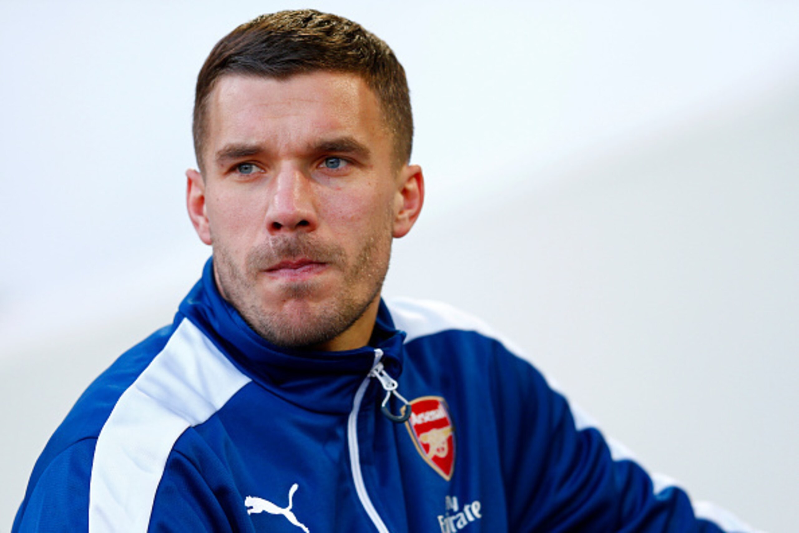 LONDON, ENGLAND - DECEMBER 28:  Lukas Podolski of Arsenal takes his seat on the bench before the Barclays Premier League match between West Ham United and Arsenal at Boleyn Ground on December 28, 2014 in London, England.  (Photo by Julian Finney/Getty Ima