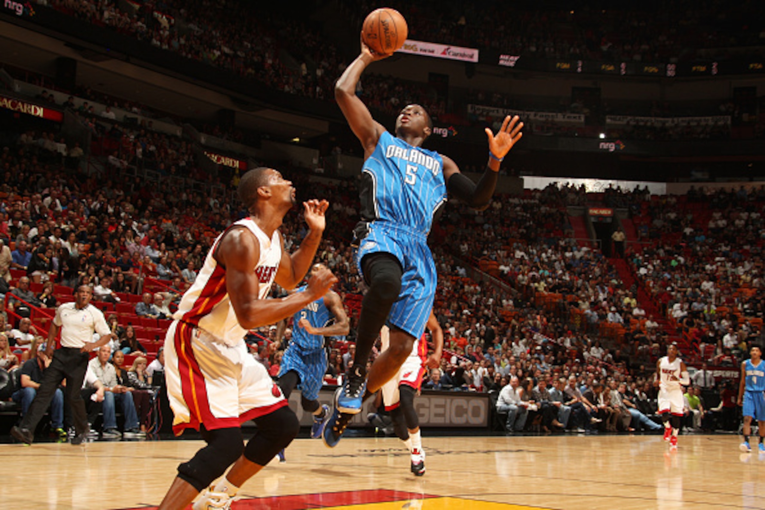 MIAMI, FL - DECEMBER 29:  Victor Oladipo #5 of the Orlando Magic shoots against Chris Bosh #1 of the Miami Heat on December 29, 2014 at American Airlines Arena in Miami, Florida.  NOTE TO USER: User expressly acknowledges and agrees that, by downloading a