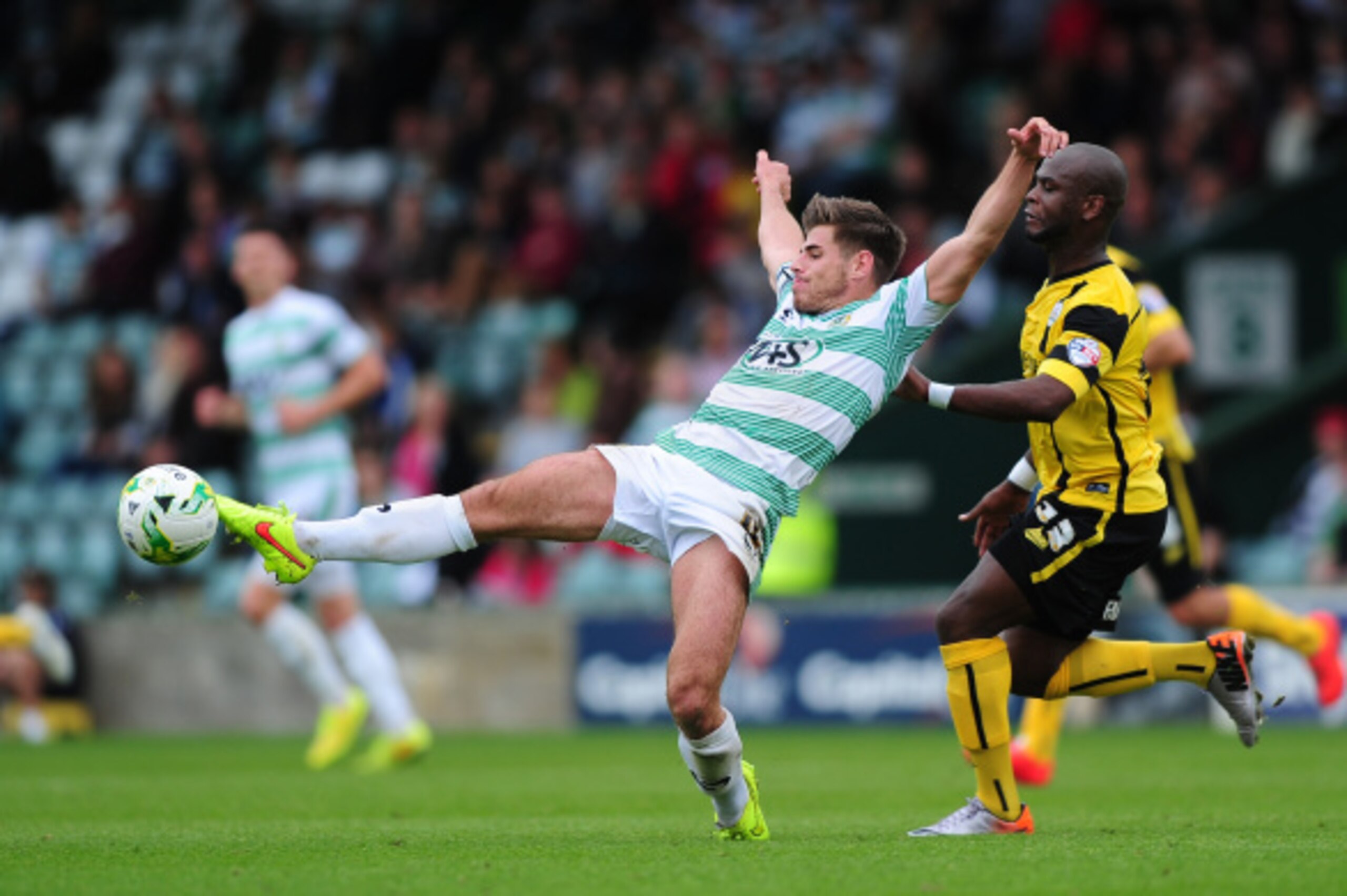 YEOVIL, ENGLAND - APRIL 30:  Joe Edwards of Yeovil (L) Town leaps to control the ball under pressure from Leroy Lita of Barnsley during the Sky Bet League One match between Yeovil Town and Barnsley at Huish Park on August 30, 2014 in Yeovil, England.  (Ph