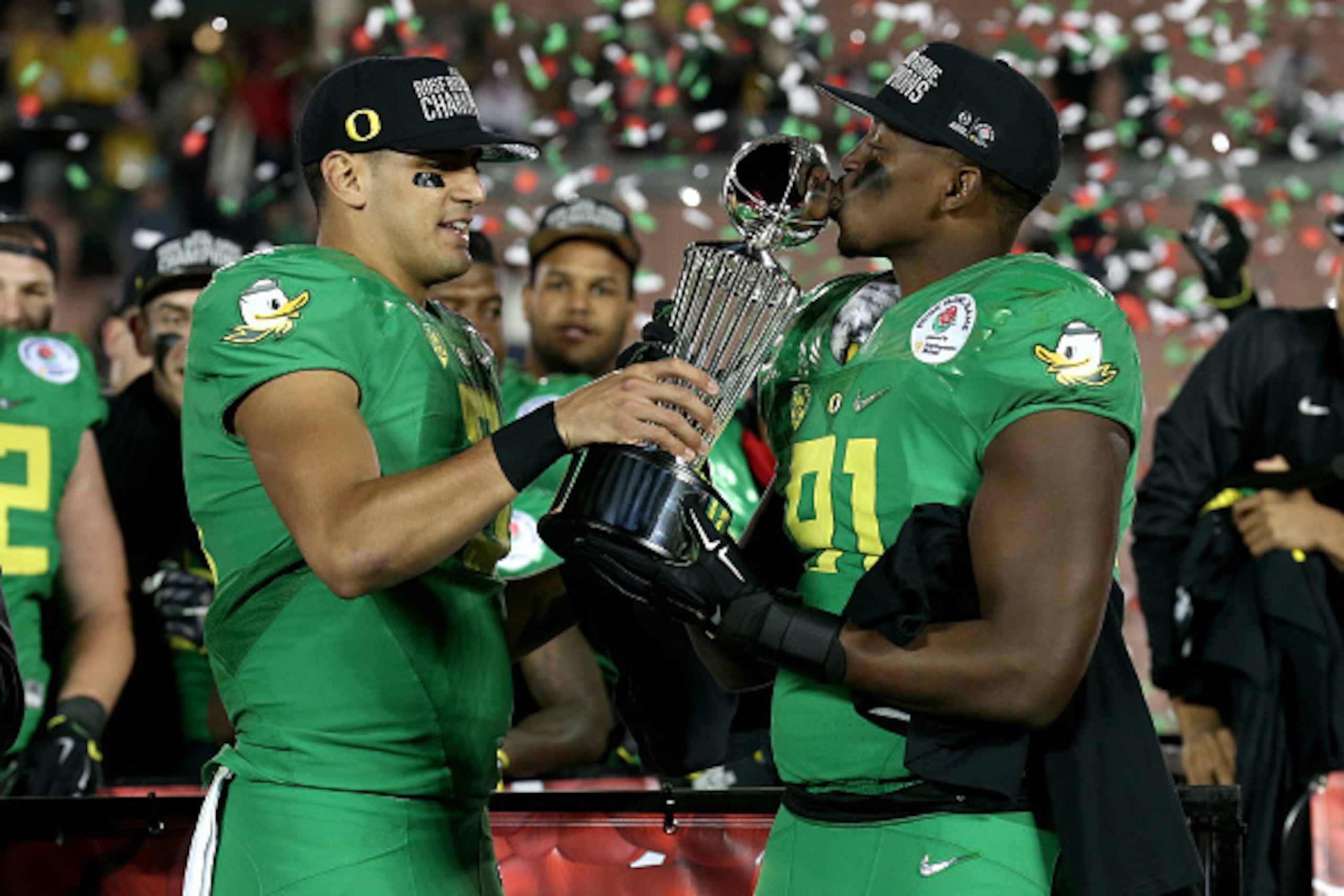 PASADENA, CA - JANUARY 01: Quarterback Marcus Mariota #8 of the Oregon Ducks hands the Leishman Trophy to linebacker Tony Washington #91 after defeating the Florida State Seminoles 59-20 in the College Football Playoff Semifinal at the Rose Bowl Game pre PASADENA, CA - JANUARY 01: Quarterback Marcus Mariota #8 of the Oregon Ducks hands the Leishman Trophy to linebacker Tony Washington #91 after defeating the Florida State Seminoles 59-20 in the College Football Playoff Semifinal at the Rose Bowl Game pre