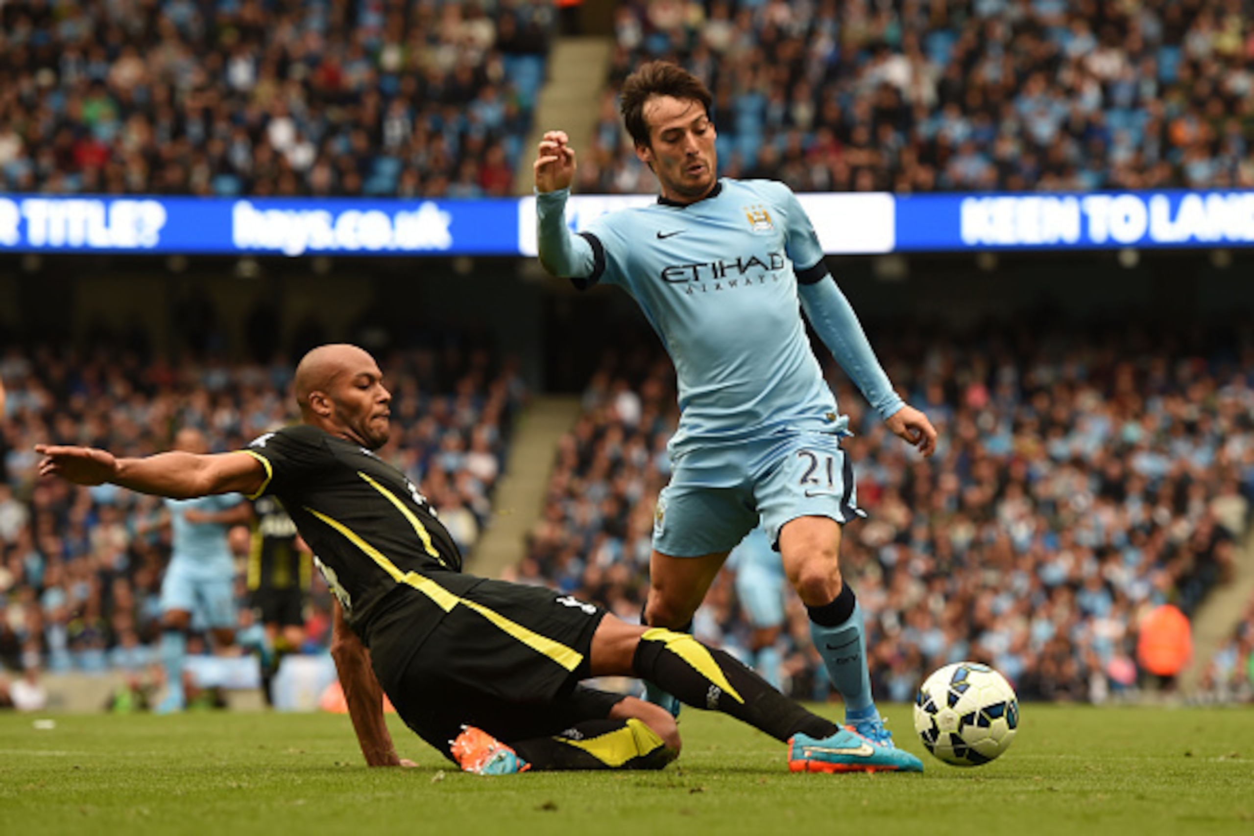 MANCHESTER, ENGLAND - OCTOBER 18:  David Silva of Manchester City wins his team's second penalty as he is brought down by Younes Kaboul of Spurs  during the Barclays Premier League match between Manchester City and Tottenham Hotspur at Etihad Stadium on O