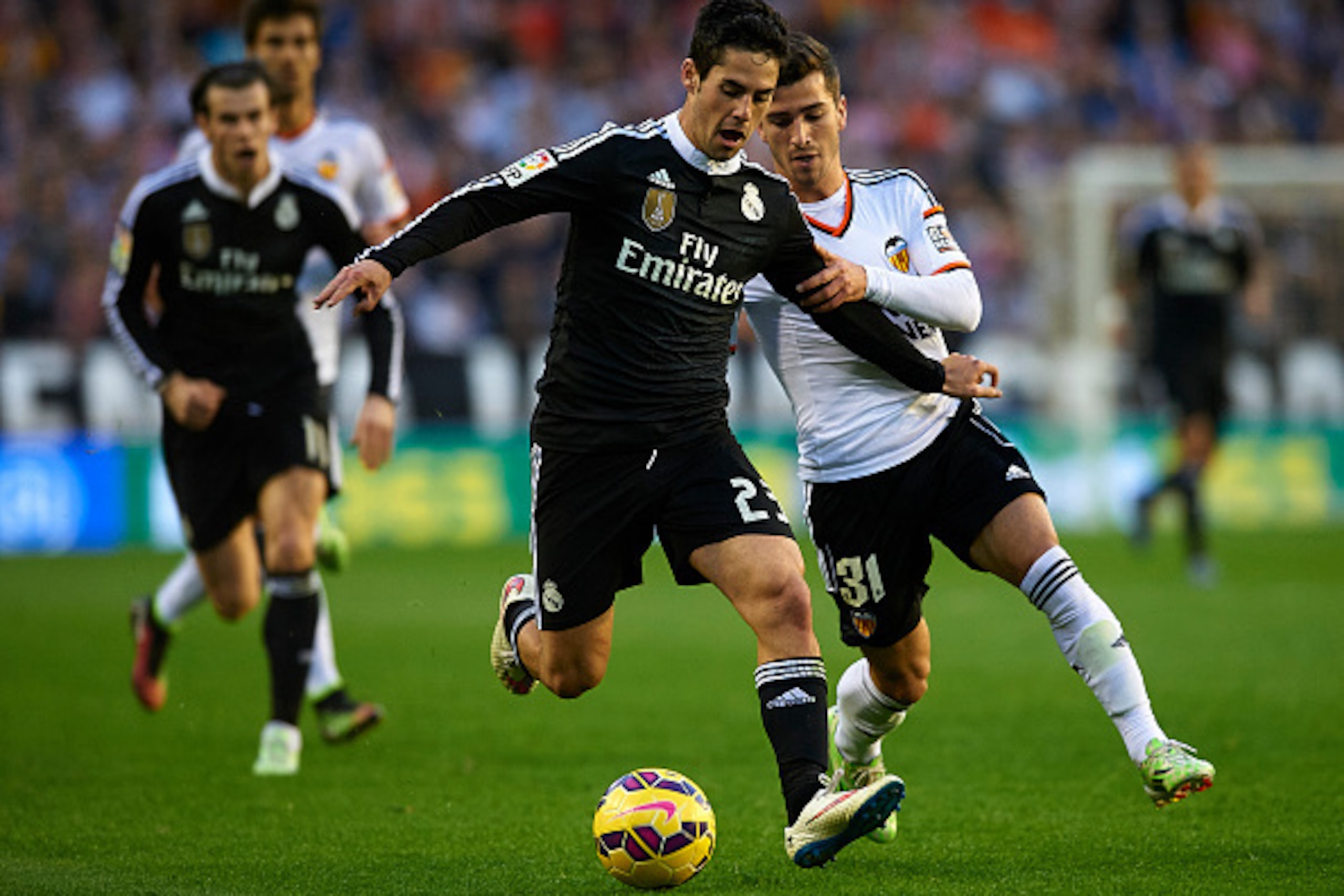 VALENCIA, SPAIN - JANUARY 04:  Jose Gaya (R) of Valencia competes for the ball with Isco of Real Madrid during the La Liga match between Valencia CF and Real Madrid CF at Estadi de Mestalla on January 4, 2015 in Valencia, Spain.  (Photo by Manuel Queimade