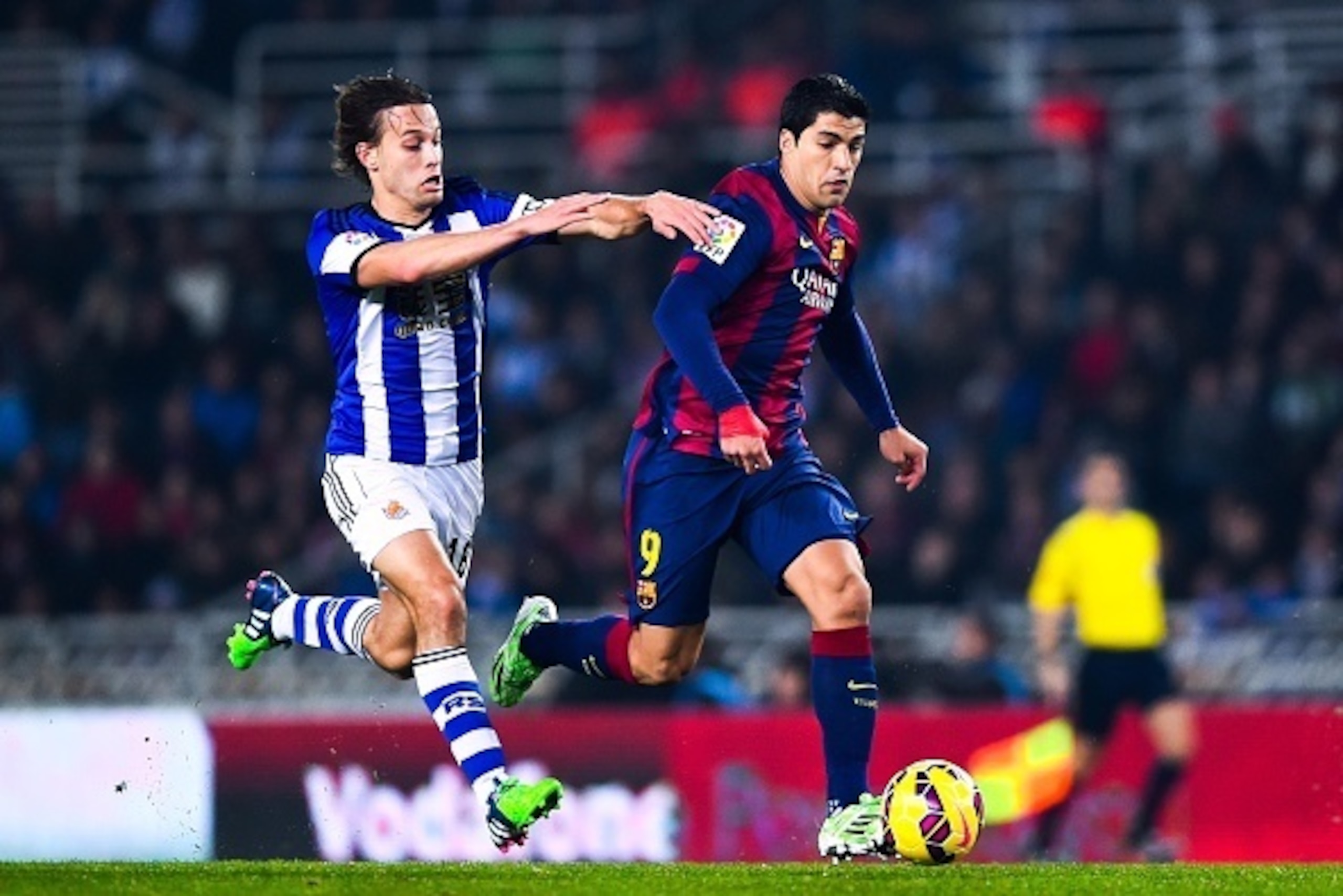 SAN SEBASTIAN, SPAIN - JANUARY 04:  Luis Suarez of FC Barcelona competes for the ball with Sergio Canales of Real Sociedad during the La Liga match between Real Sociedad de Futbol and FC Barcelona at Estadio Anoeta on January 4, 2015 in San Sebastian, Spa